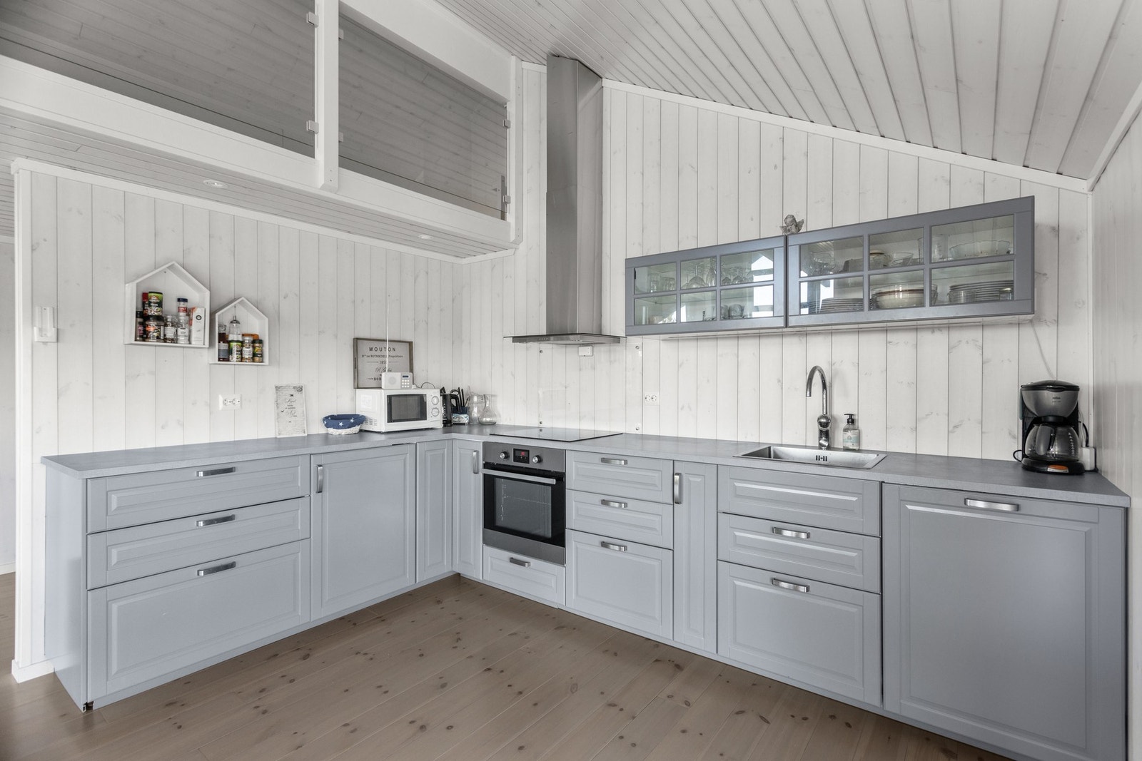 Lekker innredning med lysegrå, profilerte fronter og integrerte hvitevarer Galleribilde