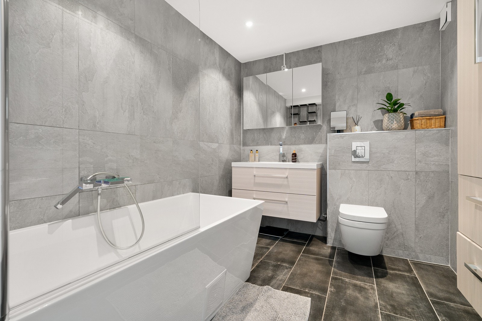 Badet ble oppgradert i 2020 og har flislagte vegger og gulv med gulvvarme, en delikat baderomsinnredning og et badekar. Galleribilde