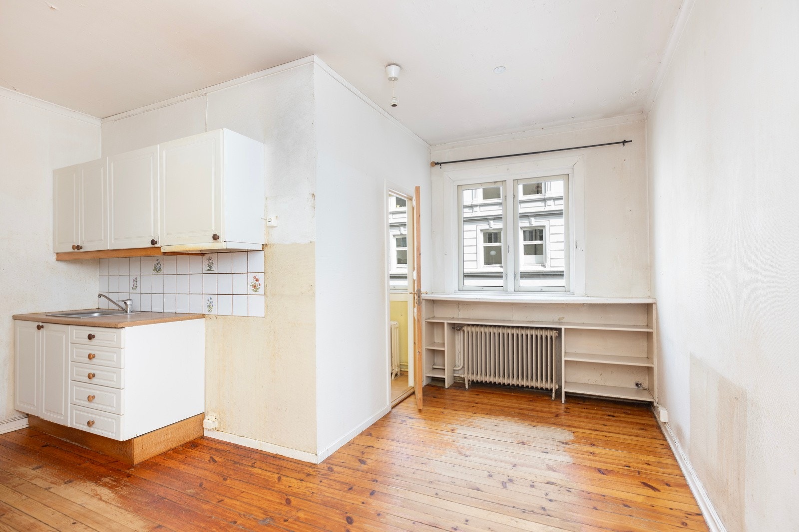 Stue med åpen kjøkkenløsning og tilgang til et mindre soverom. Galleribilde