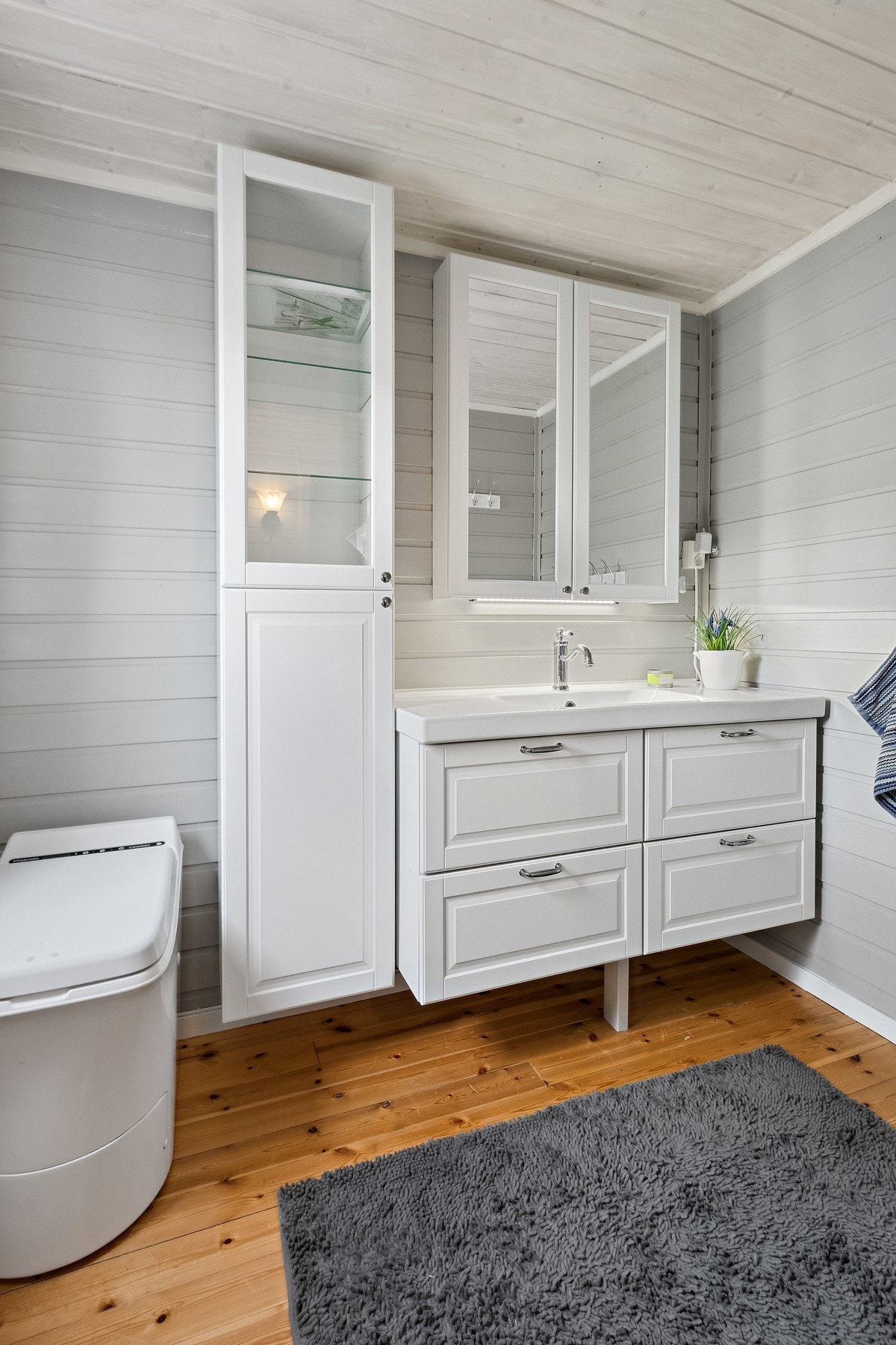 Bad/toalettrom med forbrenningstoalett, innredning med enkel servant, underskap og overskap. Galleribilde