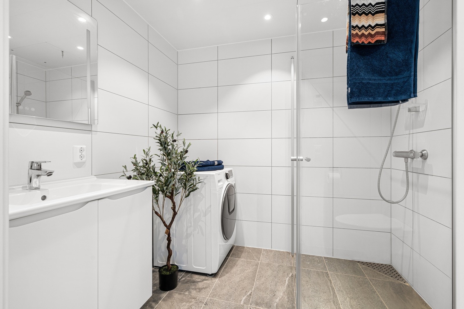 Badet er flislagt og har gulvvarme, samt godt utstyrt med bla. opplegg til vaskemaskin, mekanisk avtrekk og vegghengt servantinnredning. Galleribilde