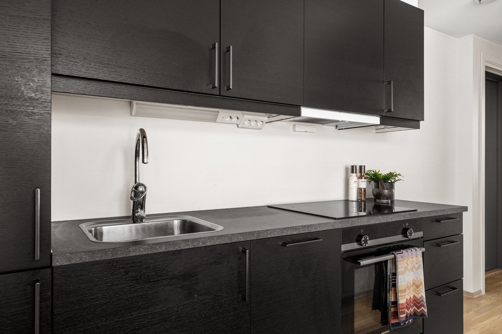 Kjøkkenet er dekorert i svarte fronter noe som gir et diskre og stilrent inntrykk. Galleribilde