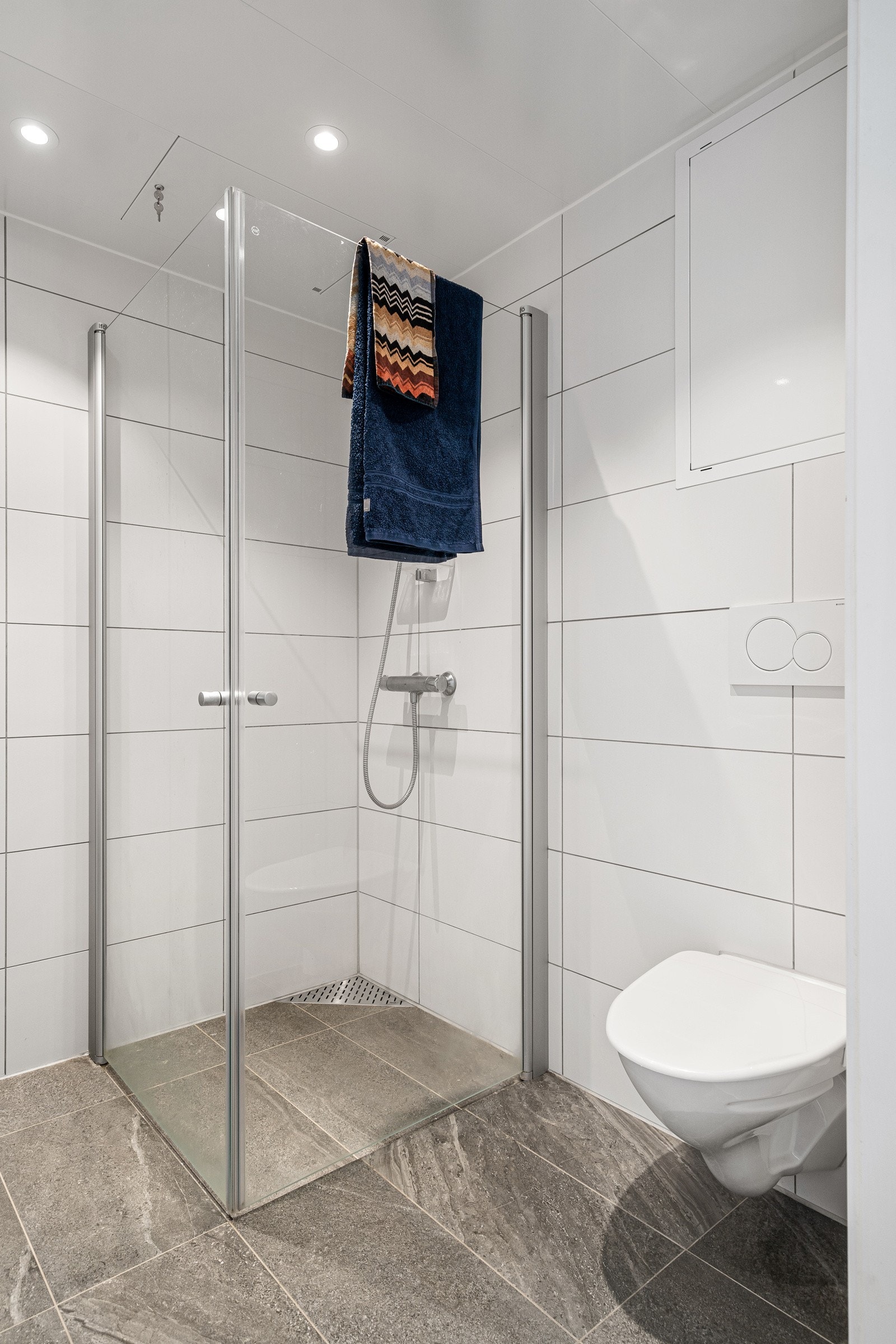 Praktisk løsning med innfellbare dusjdører som gir en bedre romfølelse når dusjen ikke er i bruk. Galleribilde