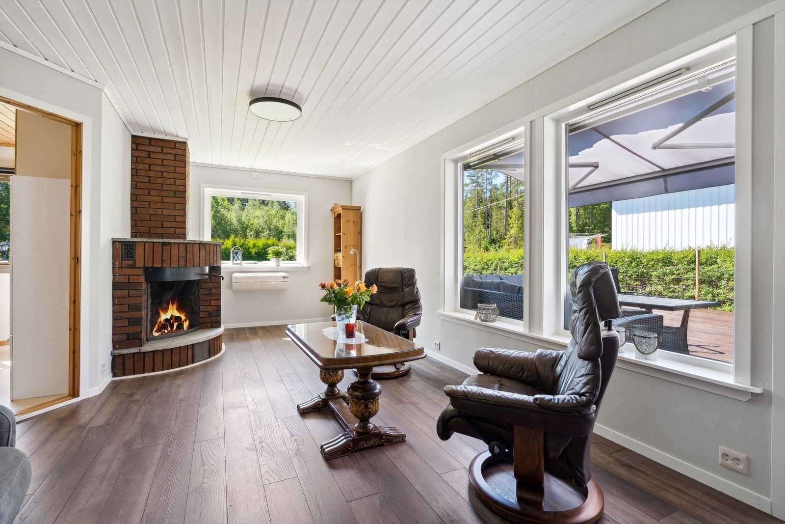 Nedre stuedelen med vedpeis, varmepumpe, store vinduer og utgang mot terrasse og soverom Galleribilde