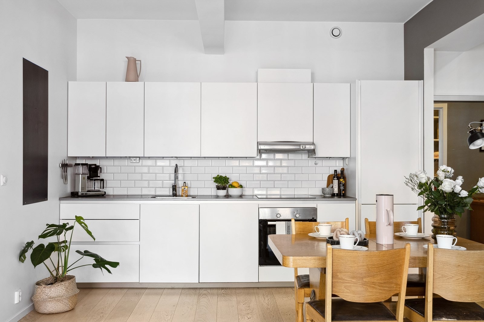 Den flotte kjøkkeninnredningen ligger fint tilbaketrukket i stuen. Innredningen har hvite, glatte fronter og benkeplate i laminat med underlimt oppvaskkum. Galleribilde