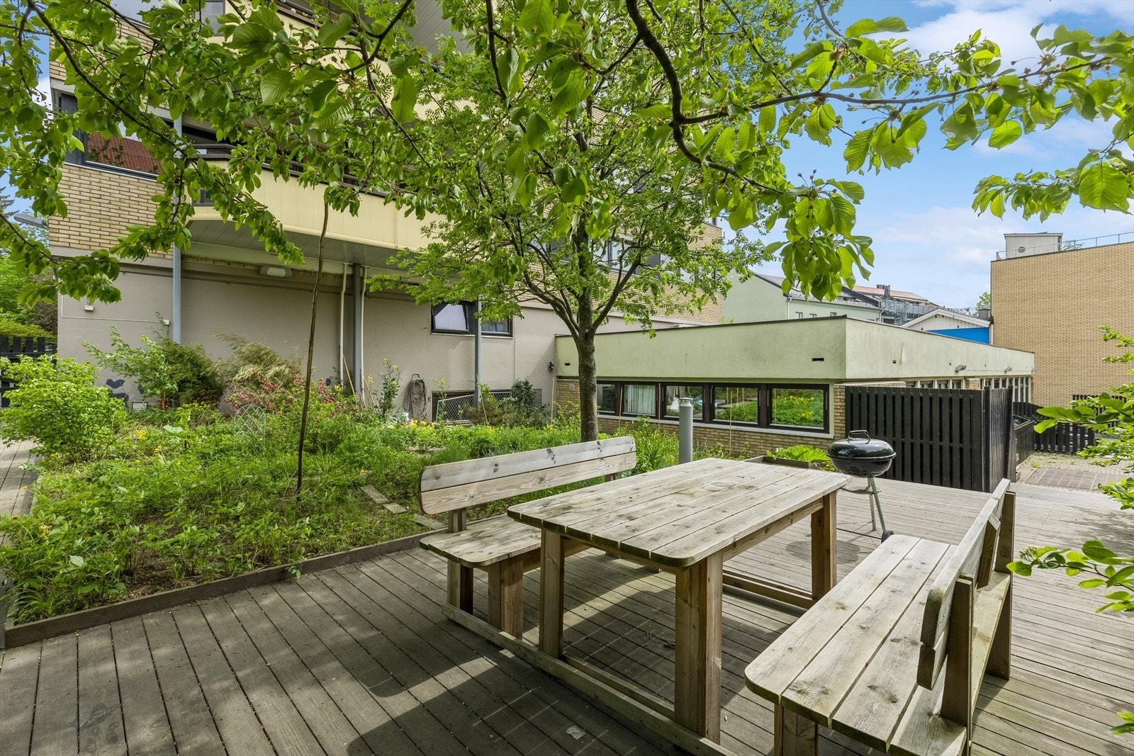 Terrasse med sitteplasser og grill. Det er også et stort sykkelrom i kjeller med direkteutgang til bakgård Galleribilde