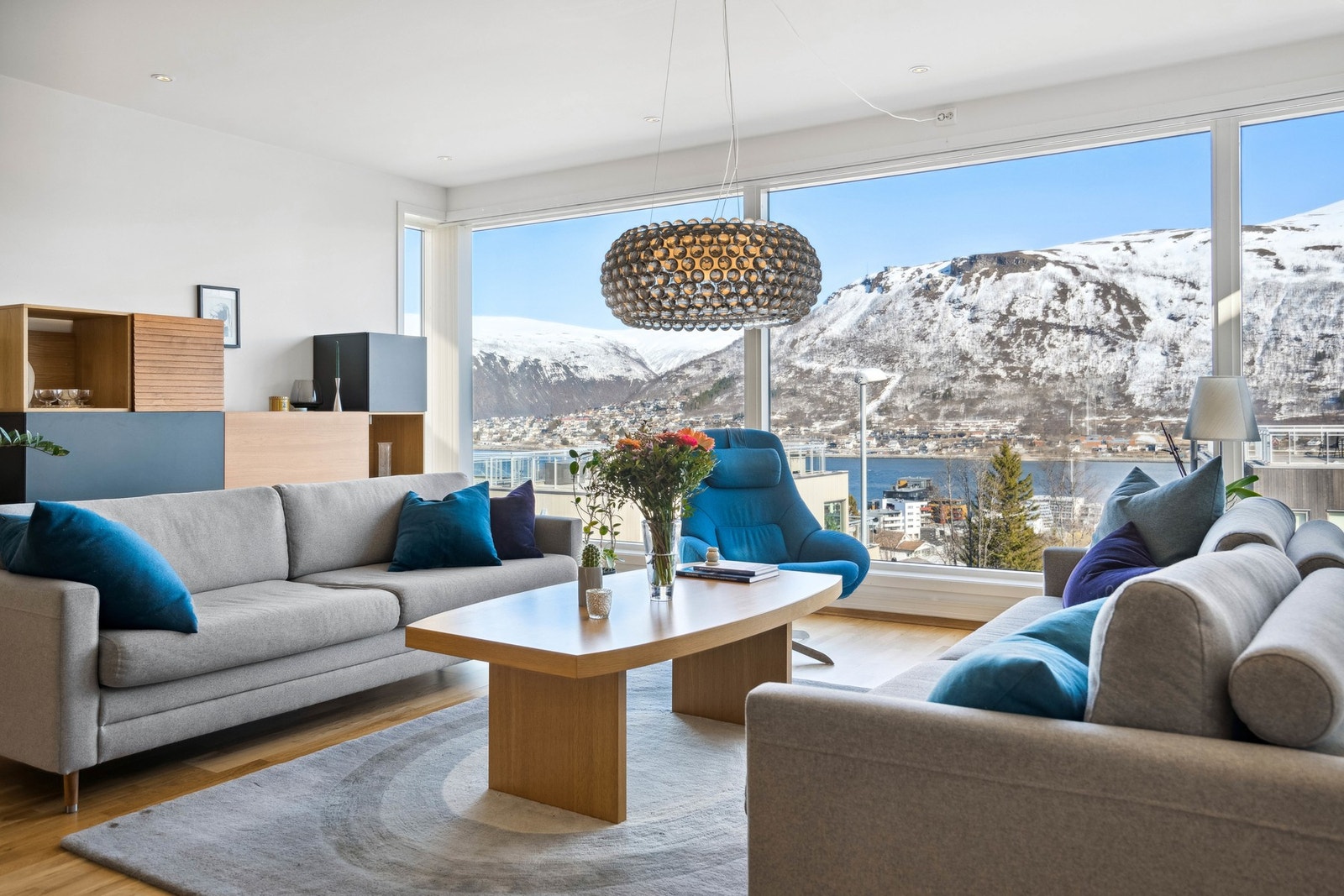 Store vindusflater fra gulv til tak med spektakulær utsikt mot Tromsøysundet, fastlandet og Fløya. Galleribilde