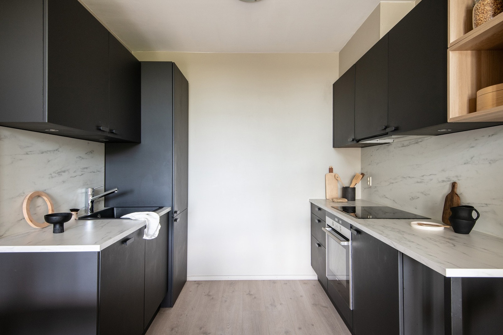 Selve innredningen har en mørk, glatt utførelse med laminat benkeplate og plate på vegg over benken. Galleribilde