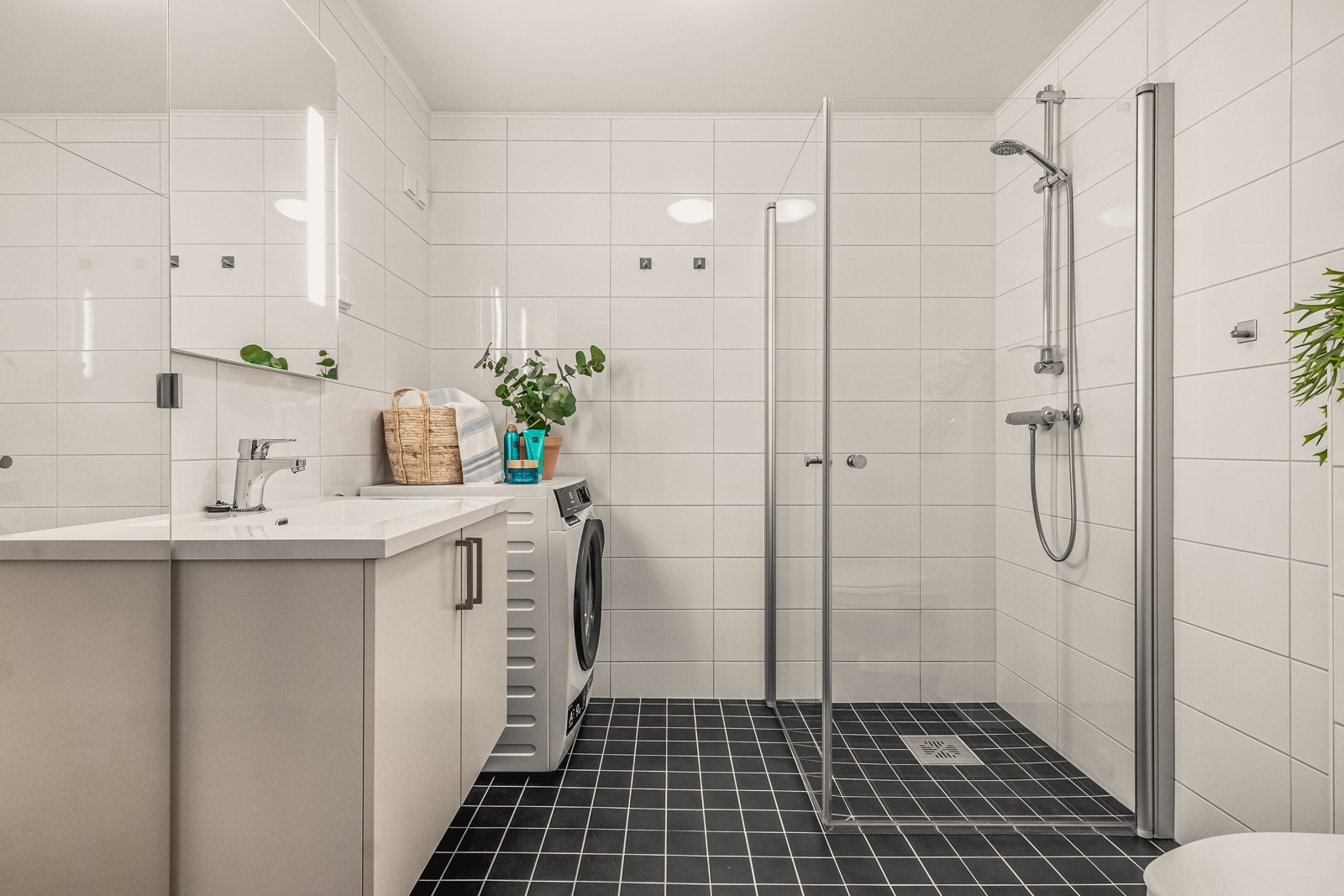 Badet er lekkert helfliset med hvite fliser på vegger og sorte fliser på gulv. Galleribilde