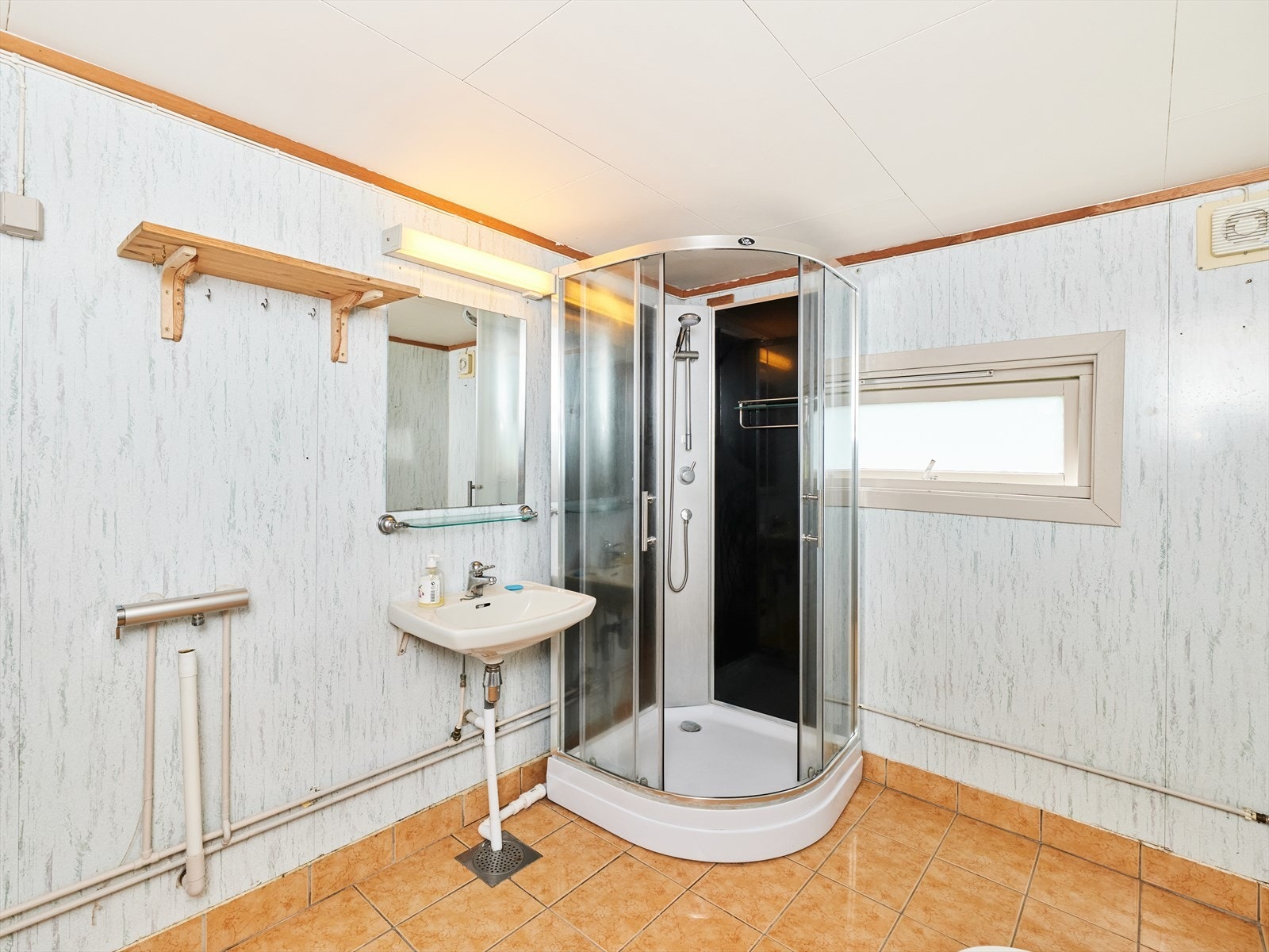 Badet er innredet med servant, dusjkabinett og toalett. Galleribilde