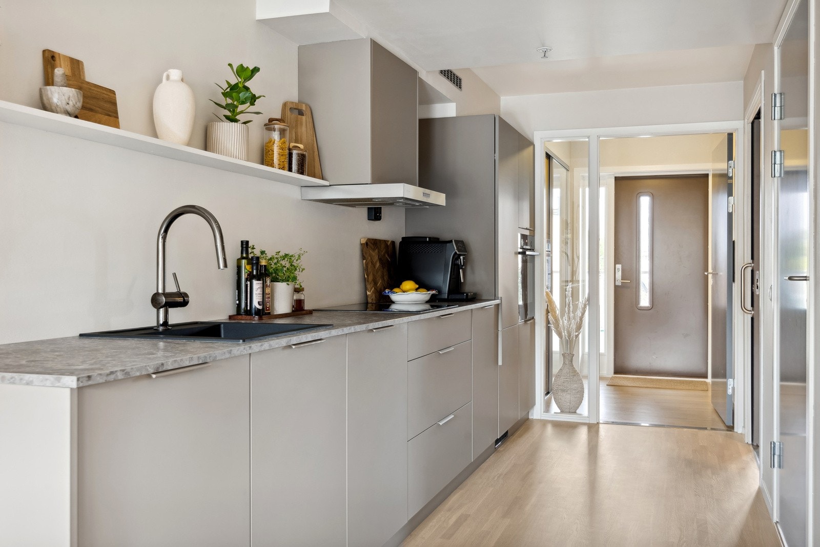 Videre inn i leiligheten ligger kjøkkenet praktisk til langs vegen. Galleribilde