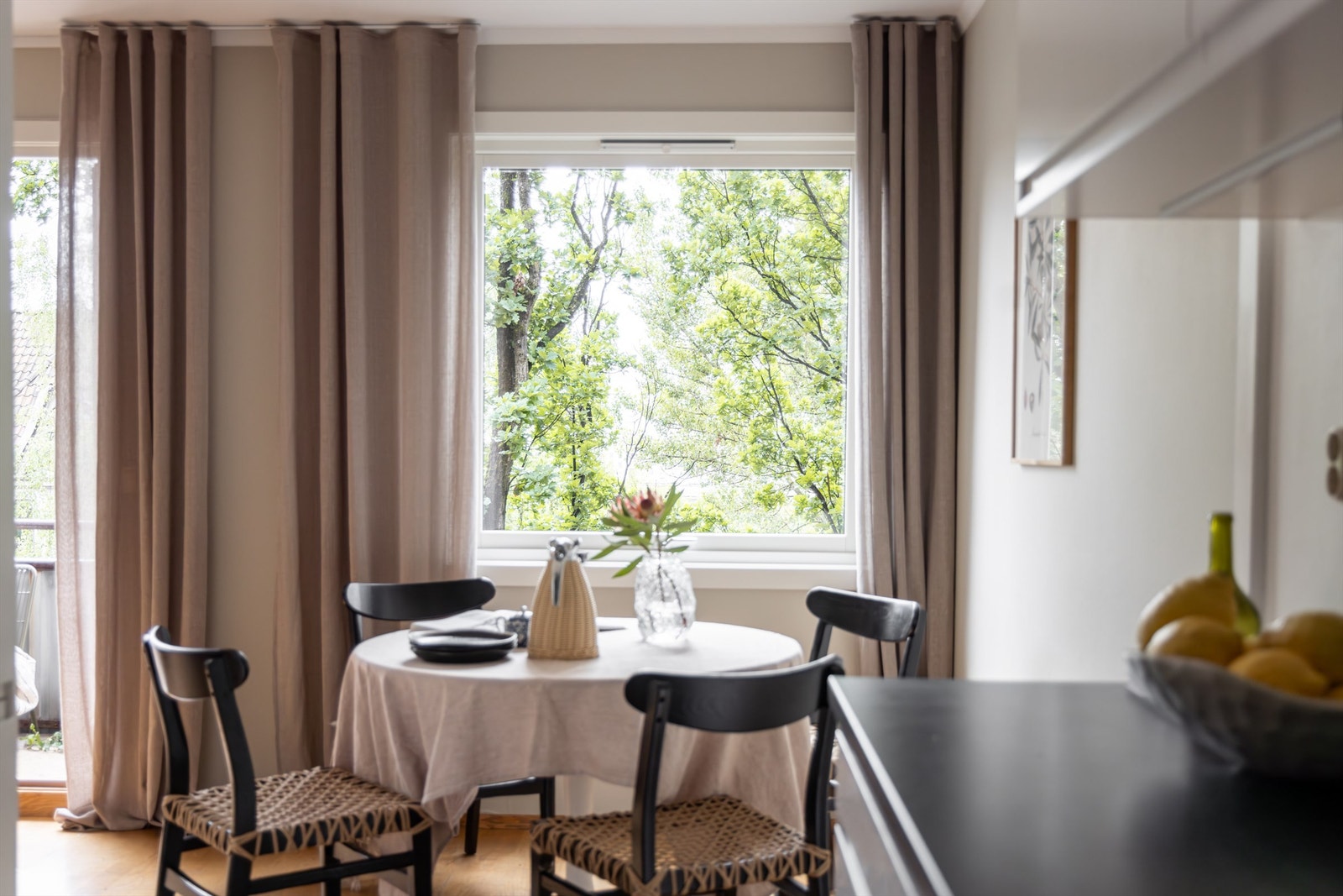 Stuens brede vindusflater slipper inn rikelig med naturlig lys som bærer over spisebordet og inn på kjøkkenet Galleribilde