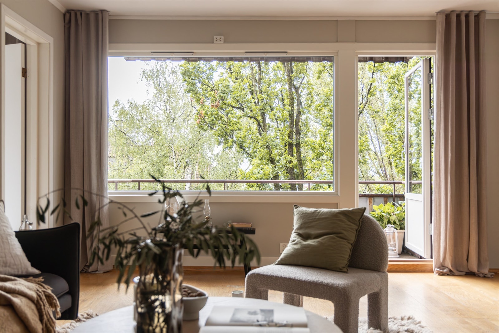 Store sydvendte vindusflater og dør ut til balkongen som gir rikelig med naturlig lys Galleribilde