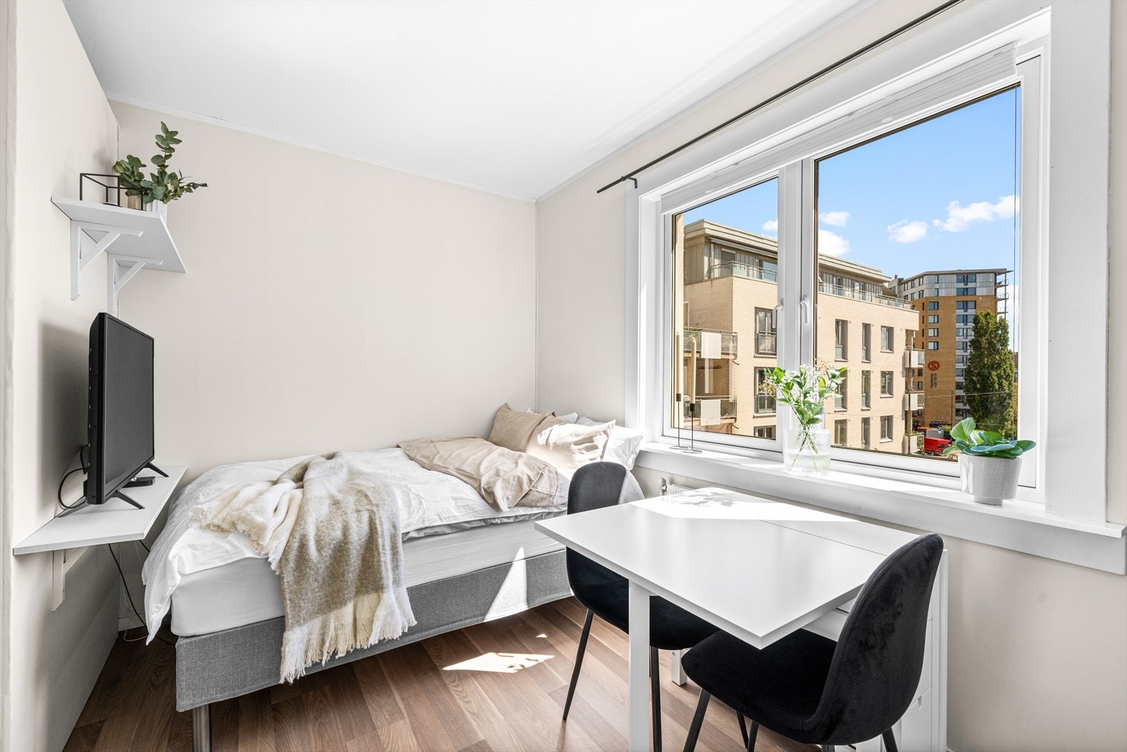 Leiligheten har en praktisk planløsning med plass til seng og spisebord med flott utsikt. Galleribilde