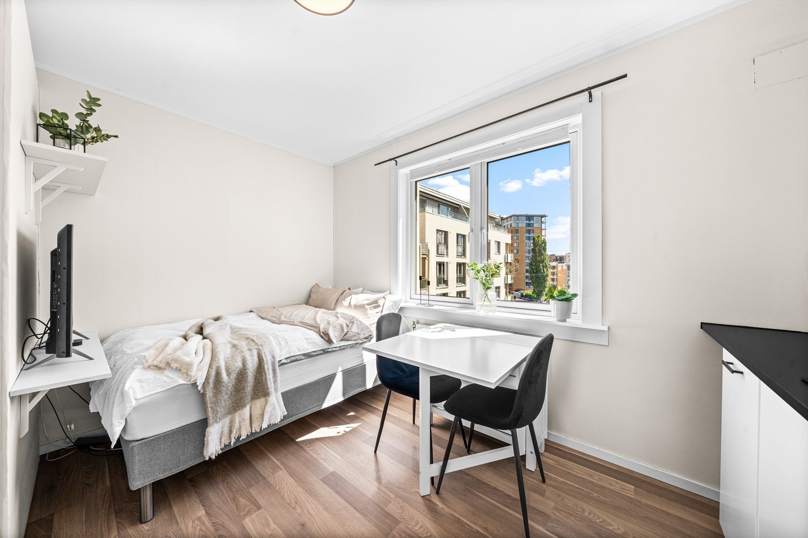 Hyggelig sovehjørne med store vinduer og utsikt over nabolaget. Galleribilde