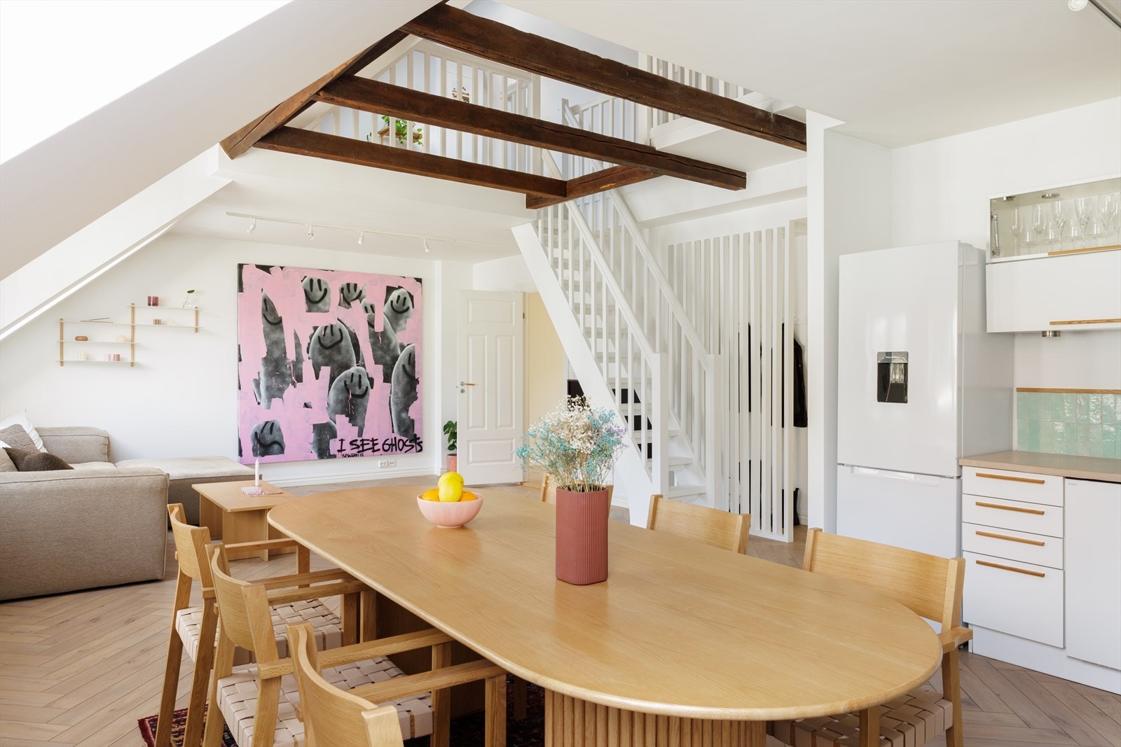 Leiligheten går over 2. plan og har opp til 5 meter takhøyde(!). Legg også merke til de synlige takbjelkene som er hentet frem. Galleribilde