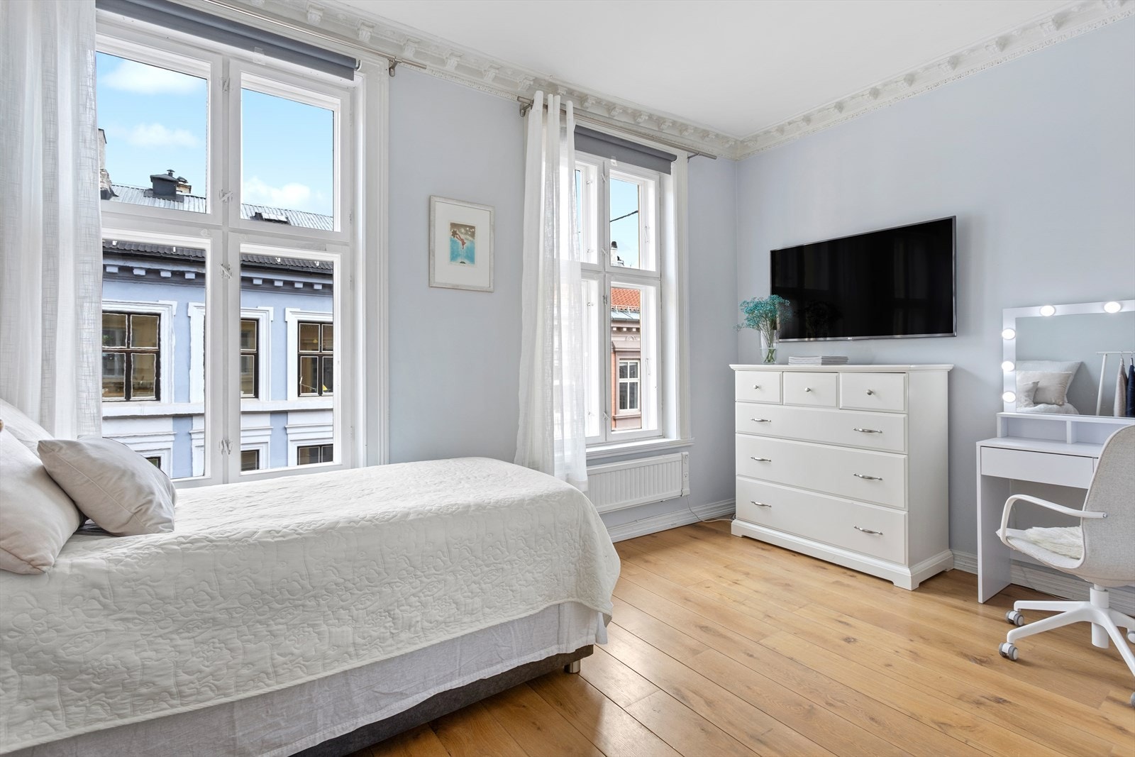 Lyst og luftig soverom med stukkatur i himling og store vindusflater som slipper inn godt med lys Galleribilde