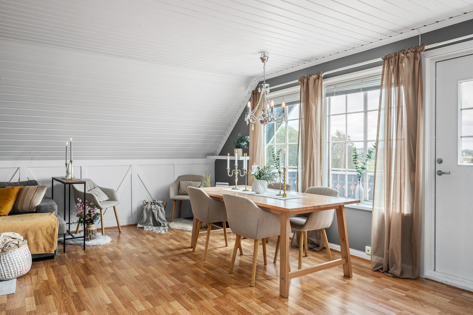 Store vindusflater gir godt med naturlig lyst inn til stuen. Her passer det fint å plassere bord med stoler eller lage til en sosial sone. Galleribilde