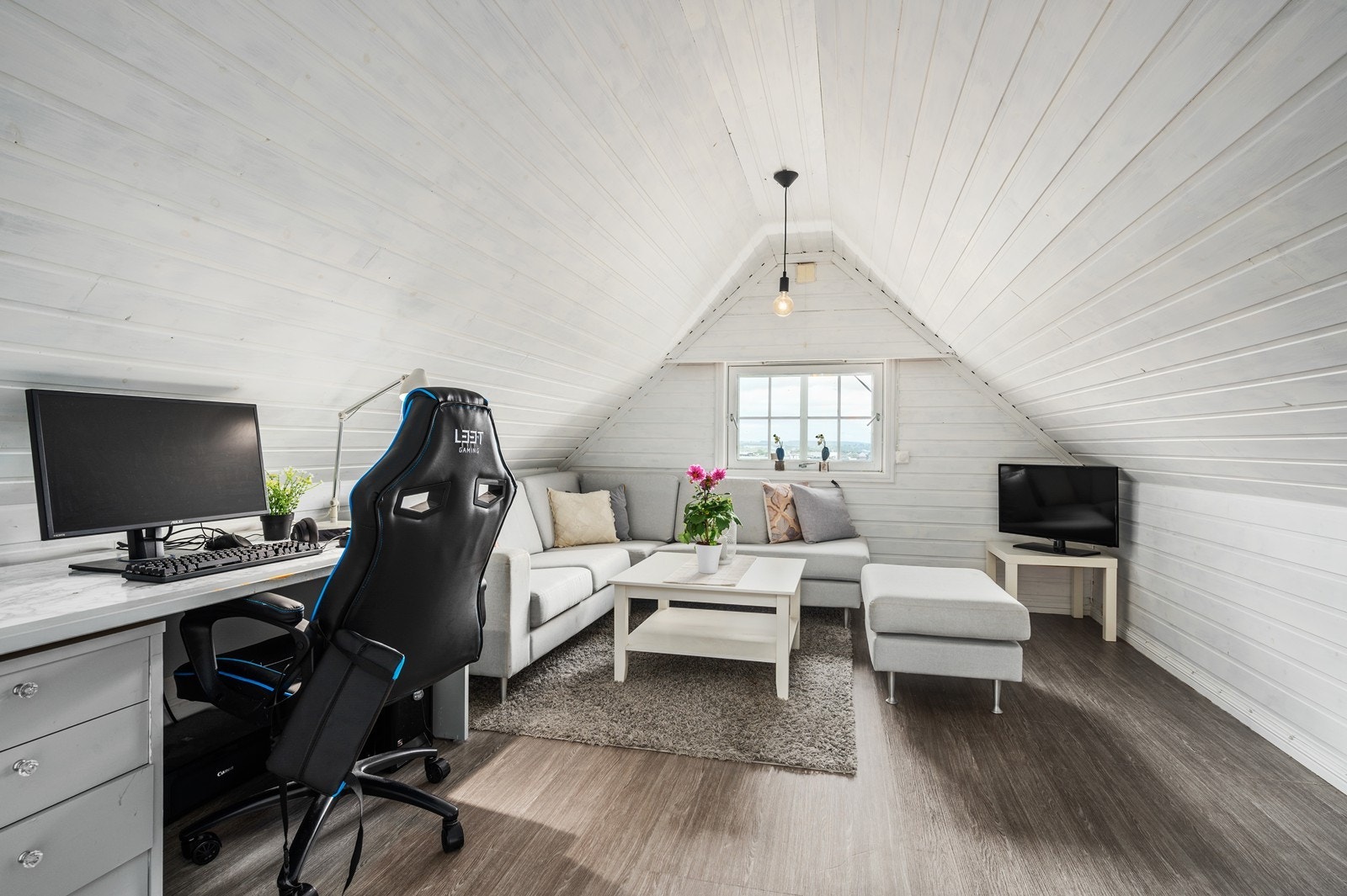 Det innredet loftstue med sofahjørne og kontorløsning. Galleribilde