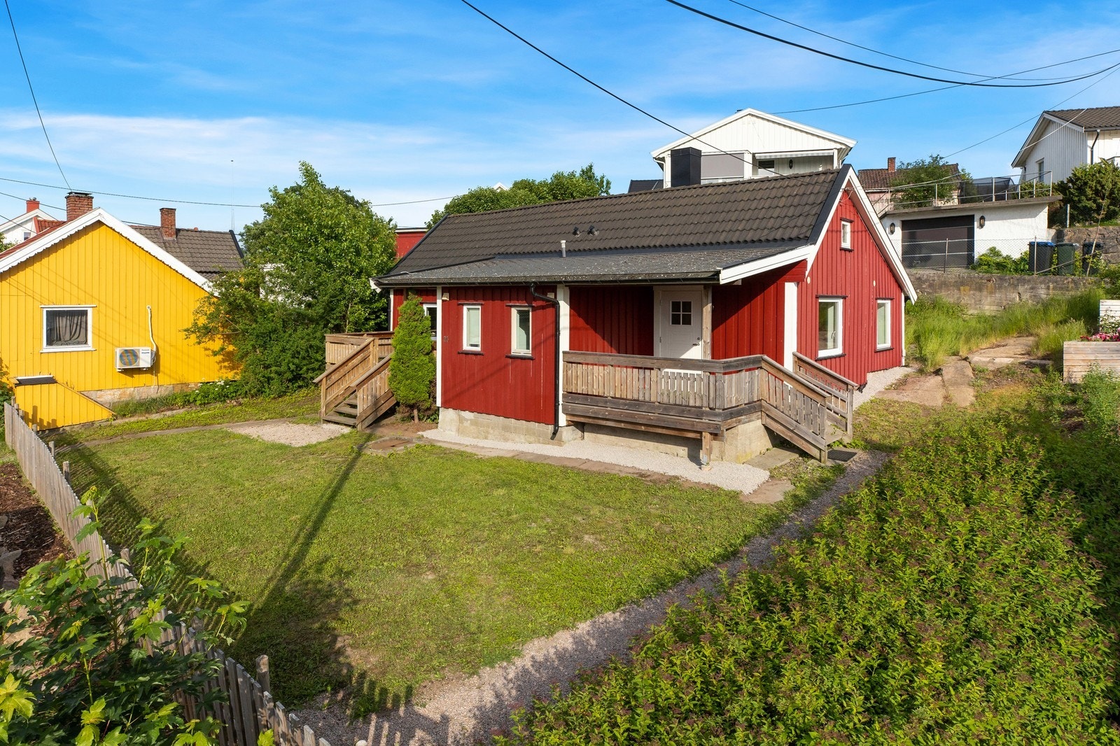 Leilighetene har hver sin veranda og deler på hagen Galleribilde