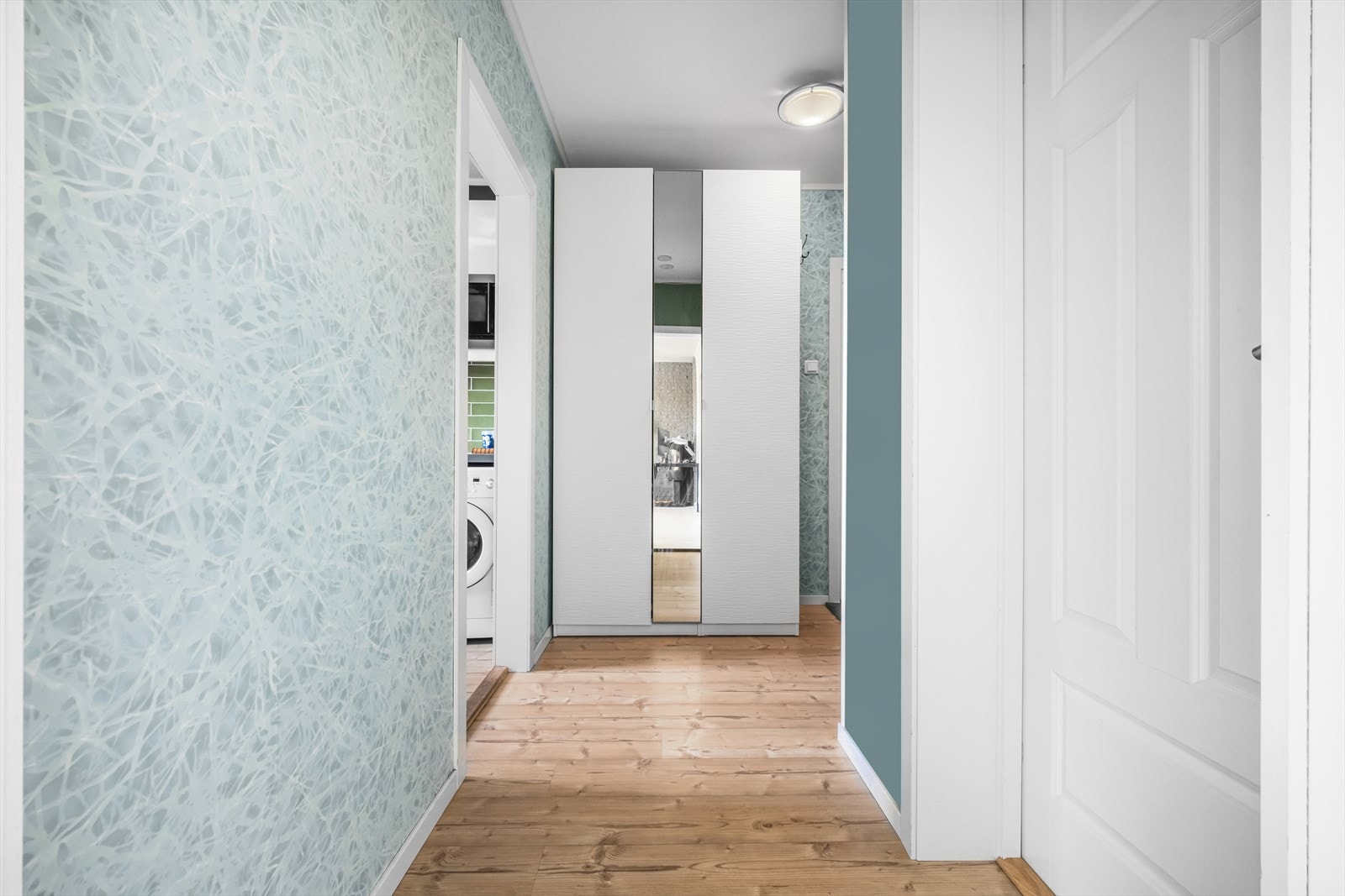 Rikelig med oppbevaringsplass i garderobeskap med speil- og glatte fronter i entrè. Galleribilde