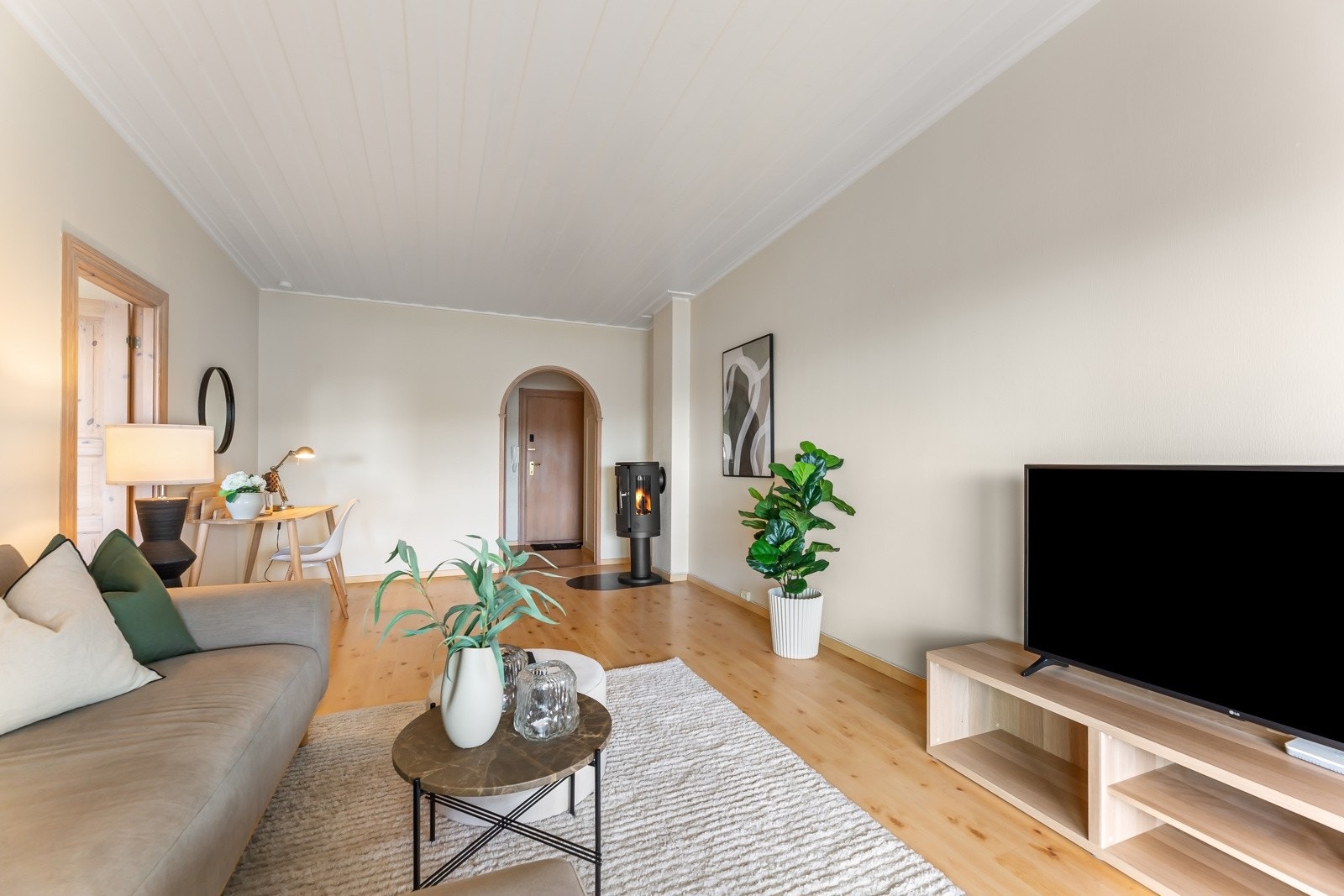 Døren fra entréen og inn til stuen har en elegant bue som harmonerer pent med de klassiske gulvene. Galleribilde