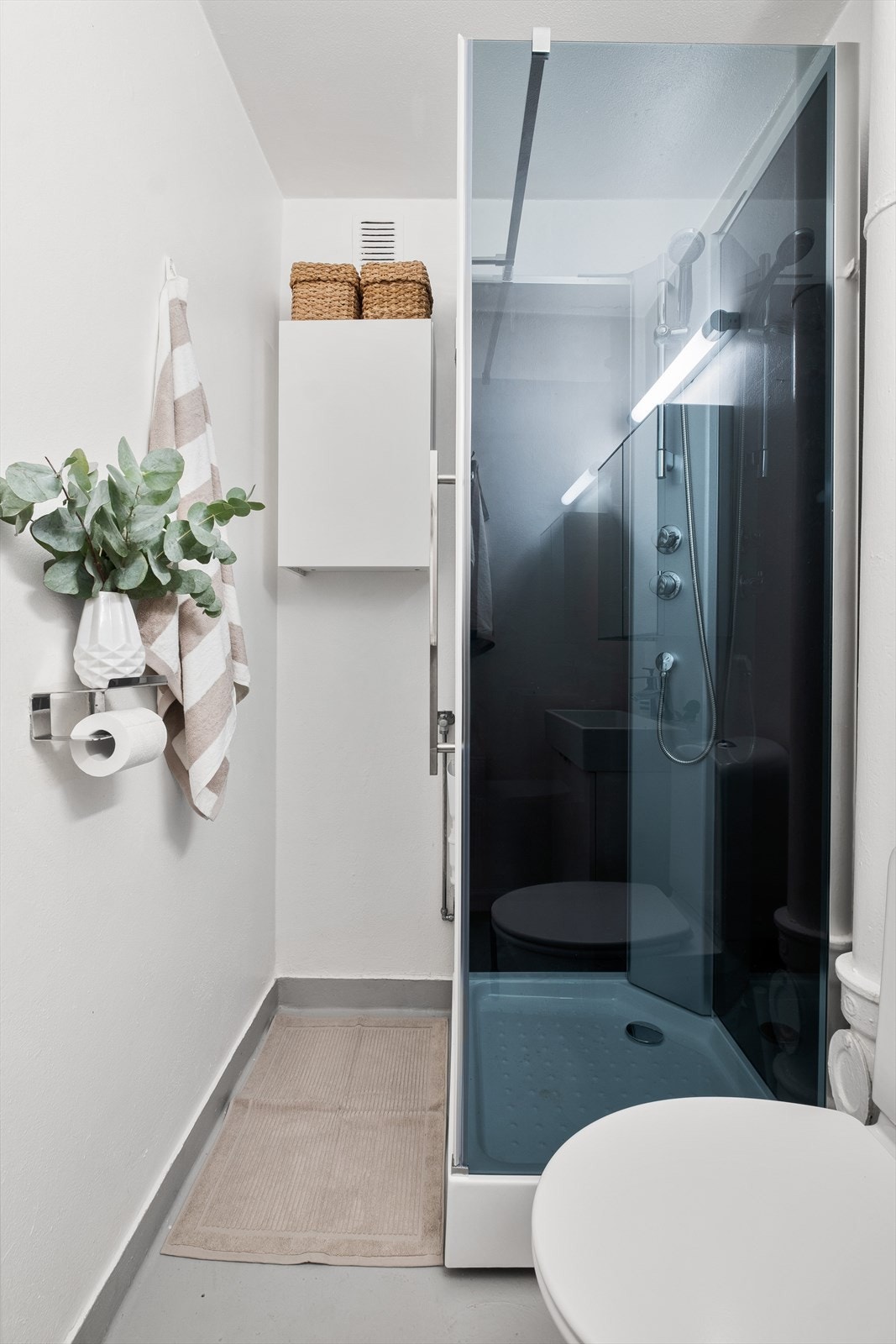 Badet er utstyrt med servant med skap, speilskap med lys, gulvmontert wc og nytt dusjkabinett fra 2024. Det er opplegg for vaskemaskin. Galleribilde