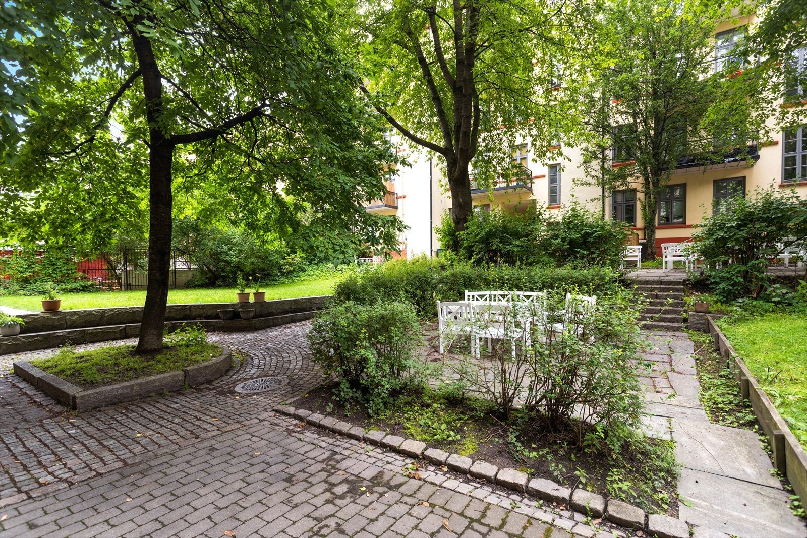 Parkmessig opparbeidet bakgård med flere sittegrupper Galleribilde