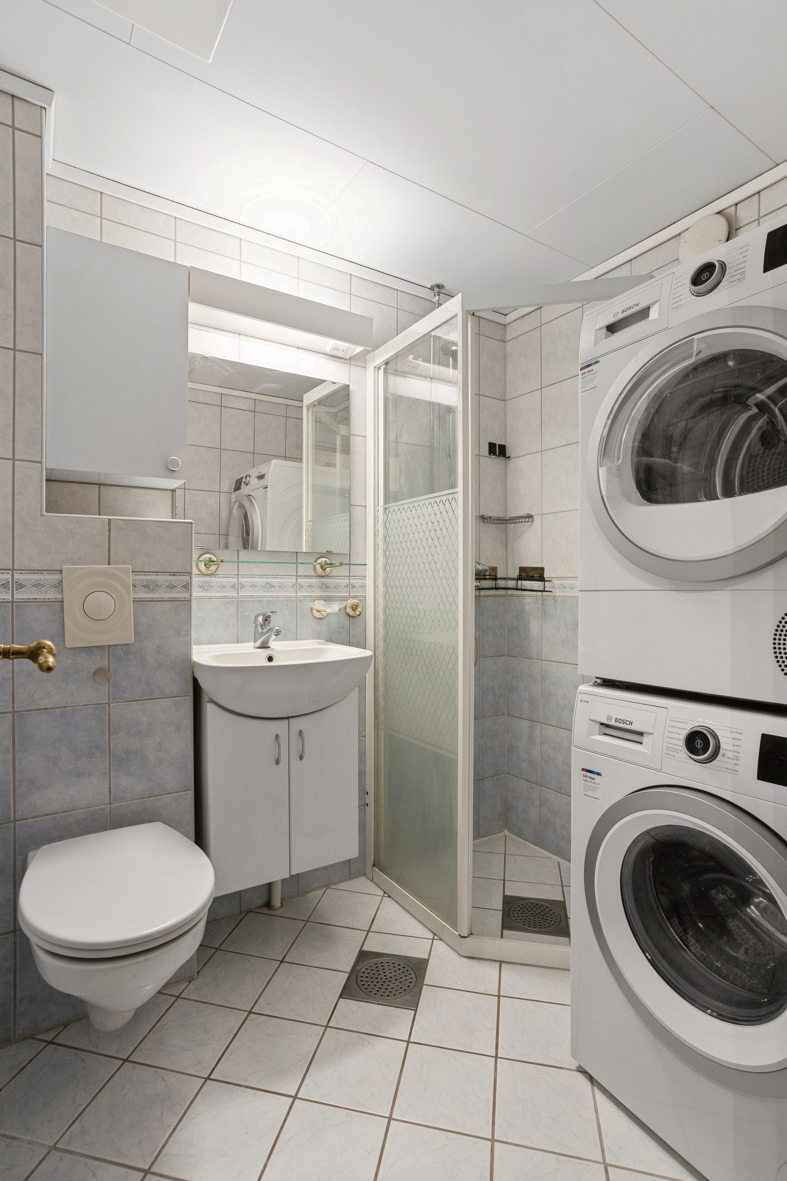 Flislagt bad med dusjhjørne av glass, vegghengt klosett og servant. Opplegg til vaskemaskin. Badet ble pusset opp av brl i 2003. Galleribilde
