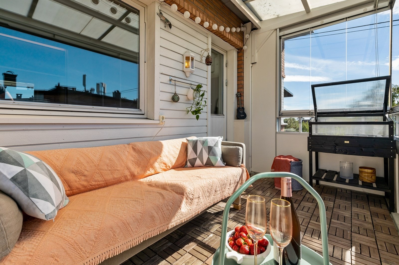 Innglasset balkong med trefliser på gulv, utebelysning og strømuttak. Galleribilde