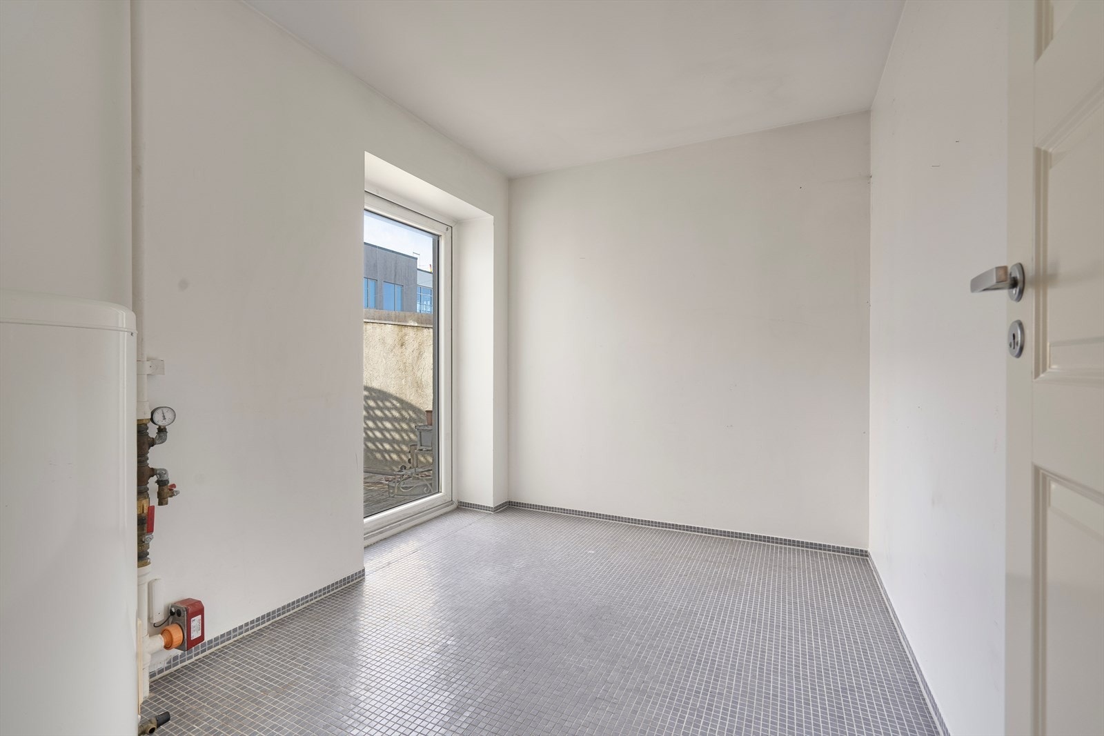 Flislagt vaskerom med terrassedør ut til terrasse Galleribilde