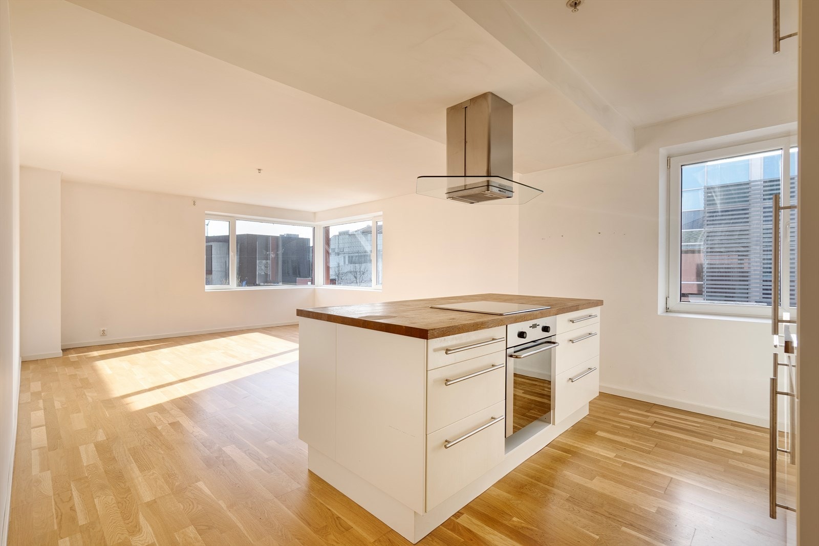 Stue med åpen kjøkkenløsning, kjekk øy med platetom, som fort kan bi leilighetens samlingspunkt. Galleribilde