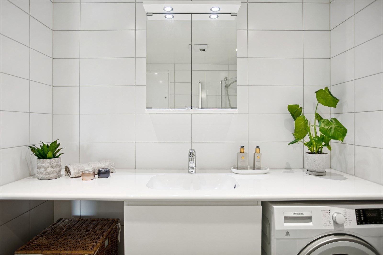 Benkeplaten strekker seg langs hele veggen, noe som gir vaskemaskinen et integrert og stilfullt utseende. Galleribilde