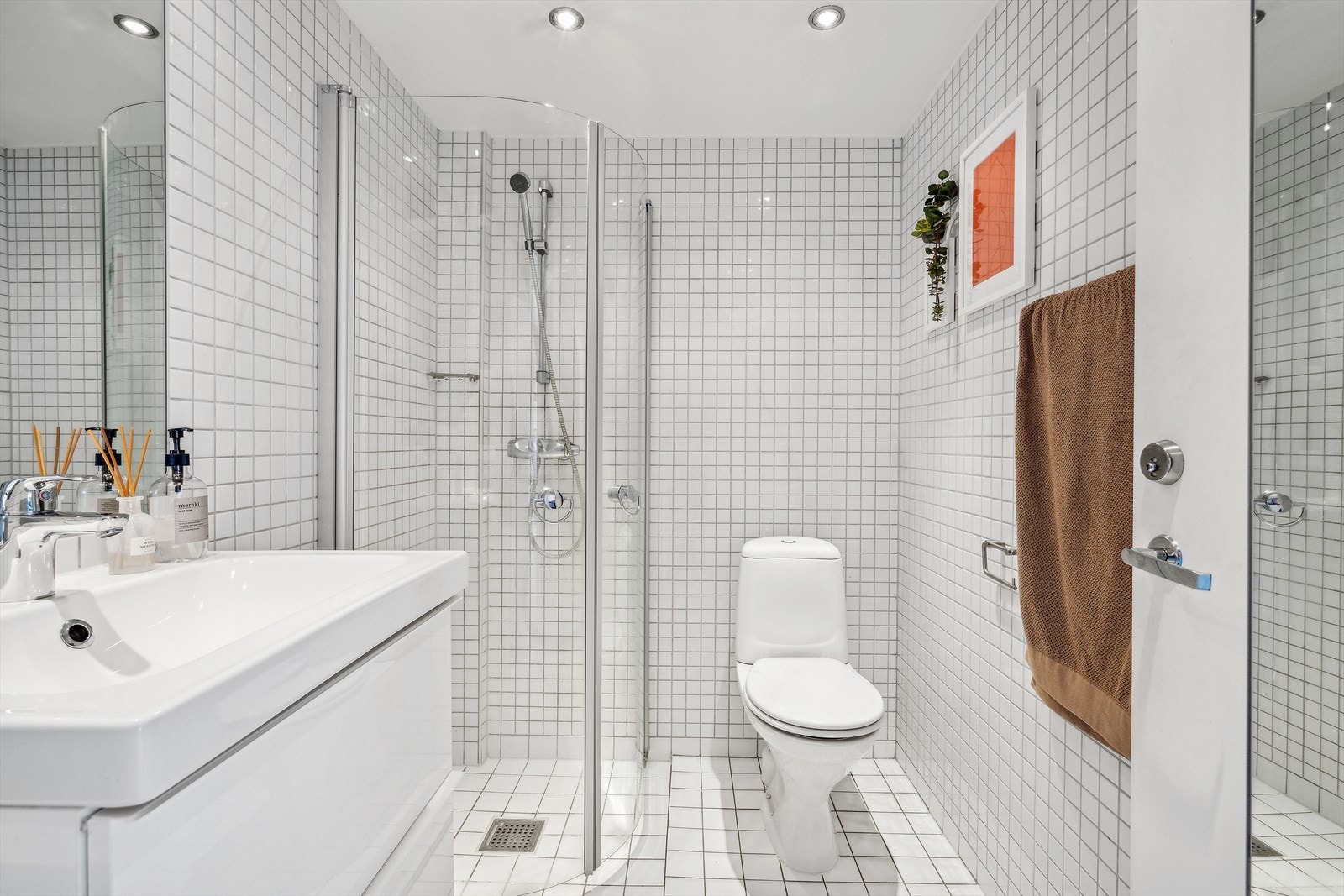 Pent flislagt baderom med varmekabler i gulvet og downlights i taket. Galleribilde