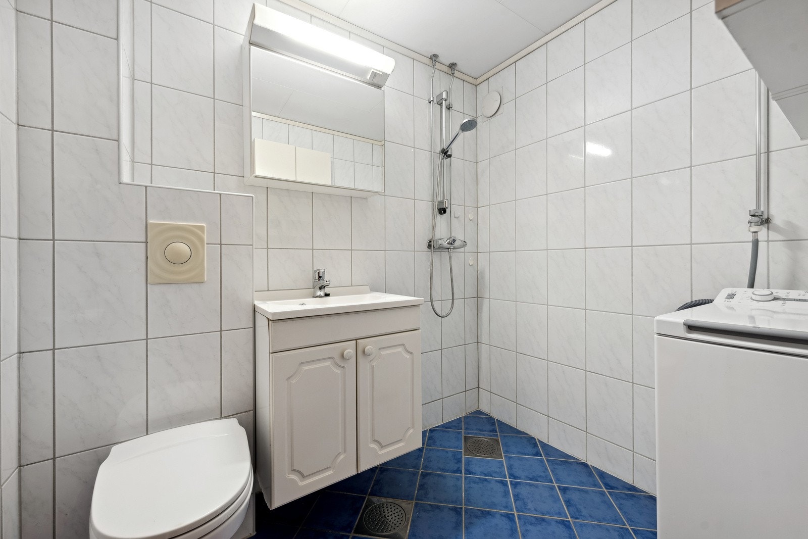Bad/wc med gulvarme, dusj, veggmonert klosett og opplegg for vaskemaskin. Galleribilde