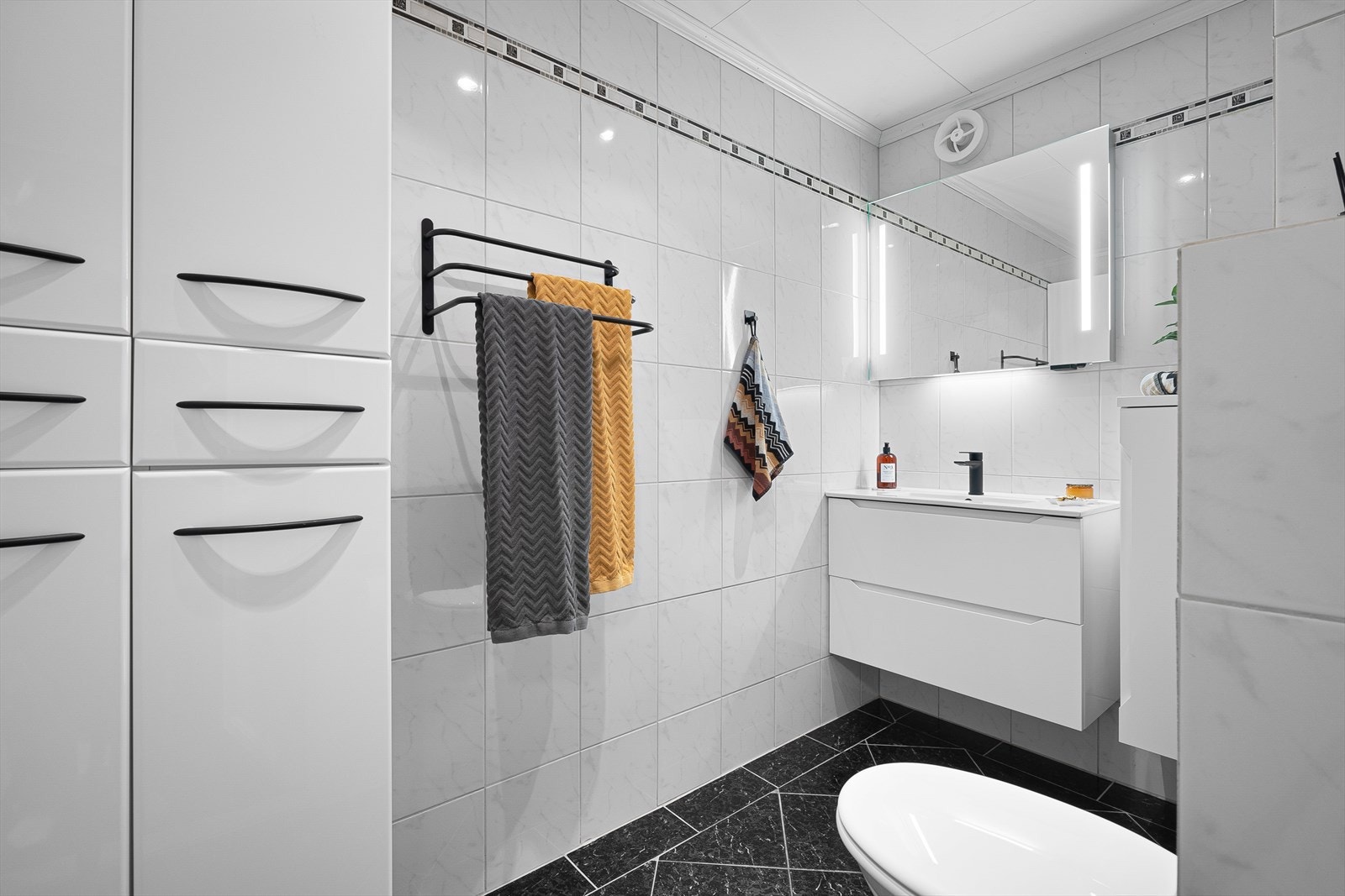 Speil med integrert belysning, veggmontert wc og varmekabler i gulvet. Galleribilde