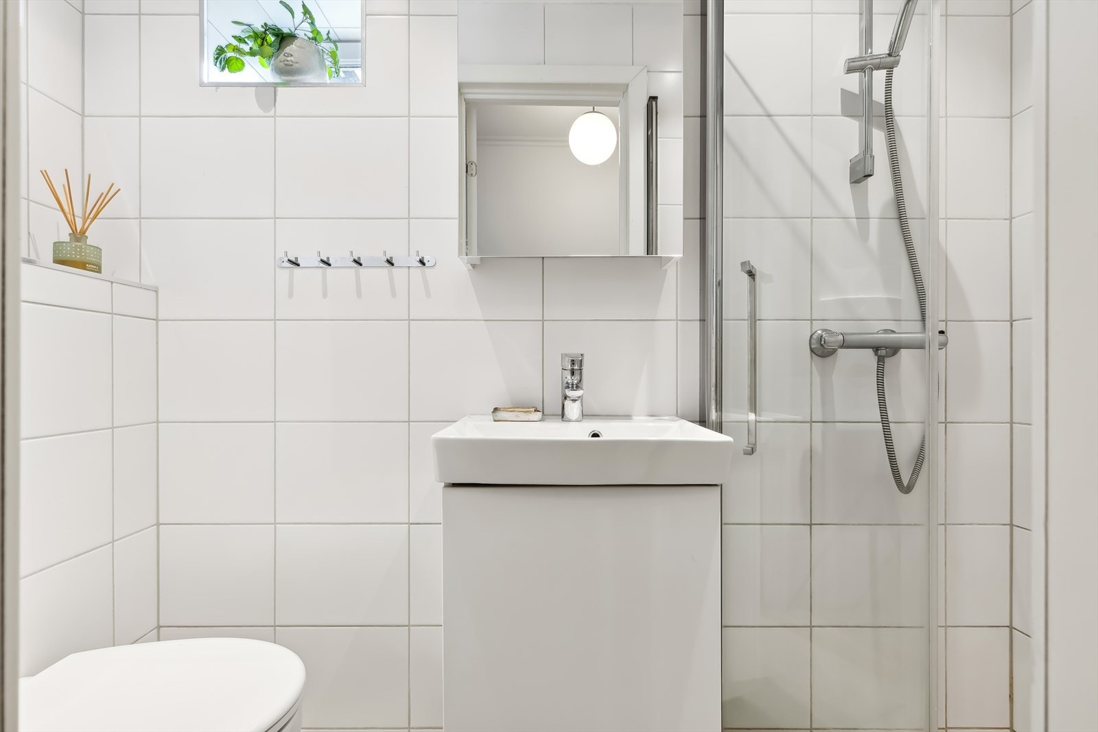 Pent og effektivt bad fra 2015 med vegghengt WC, servant i innredning og dusj. Galleribilde