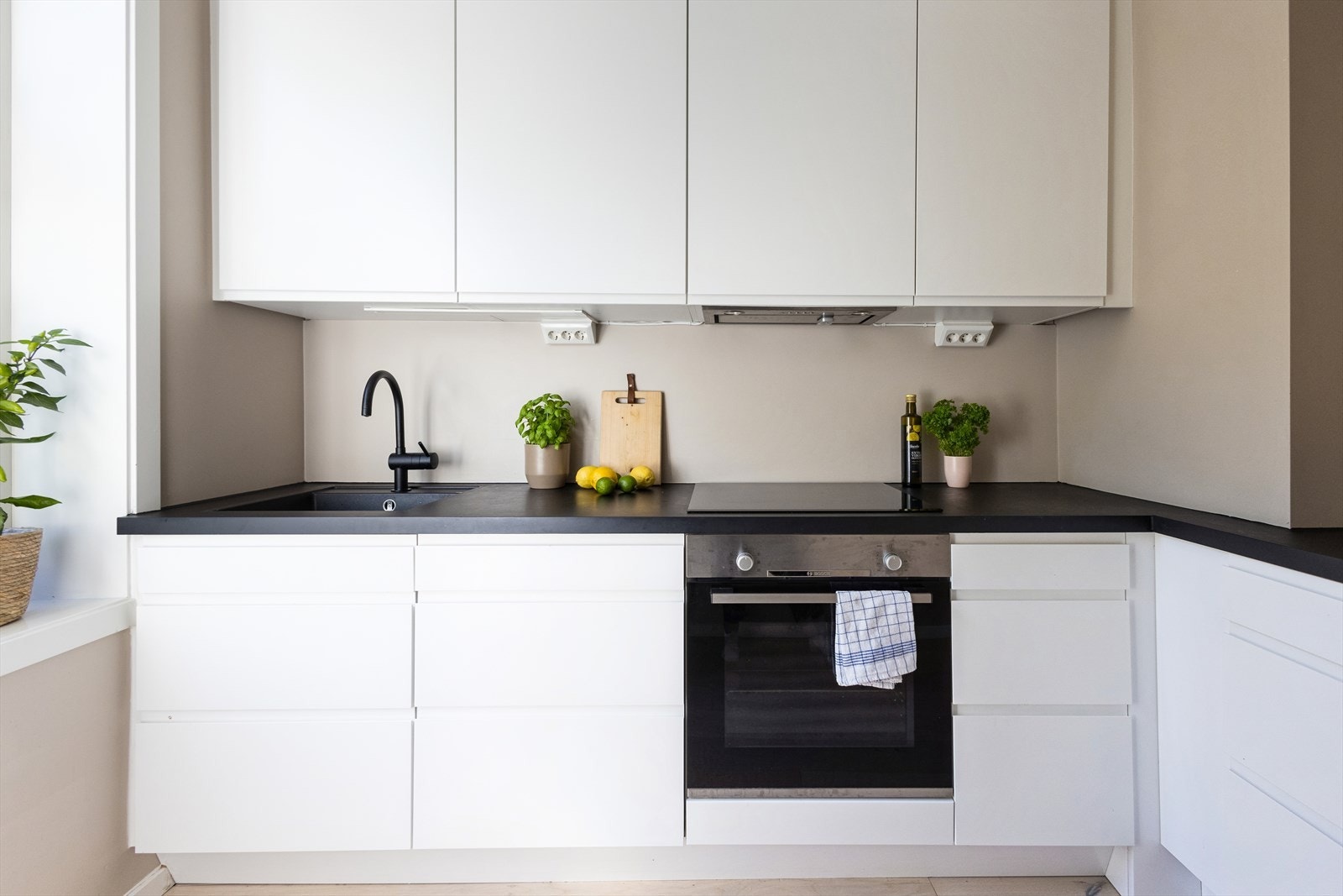 Stilrent Epoq kjøkken fra 2019. Laminat benkeplate. Nedsenket oppvaskkum fra Blanco og armatur fra Grohe. Ventilator er antatt montert til felleskanalen Galleribilde