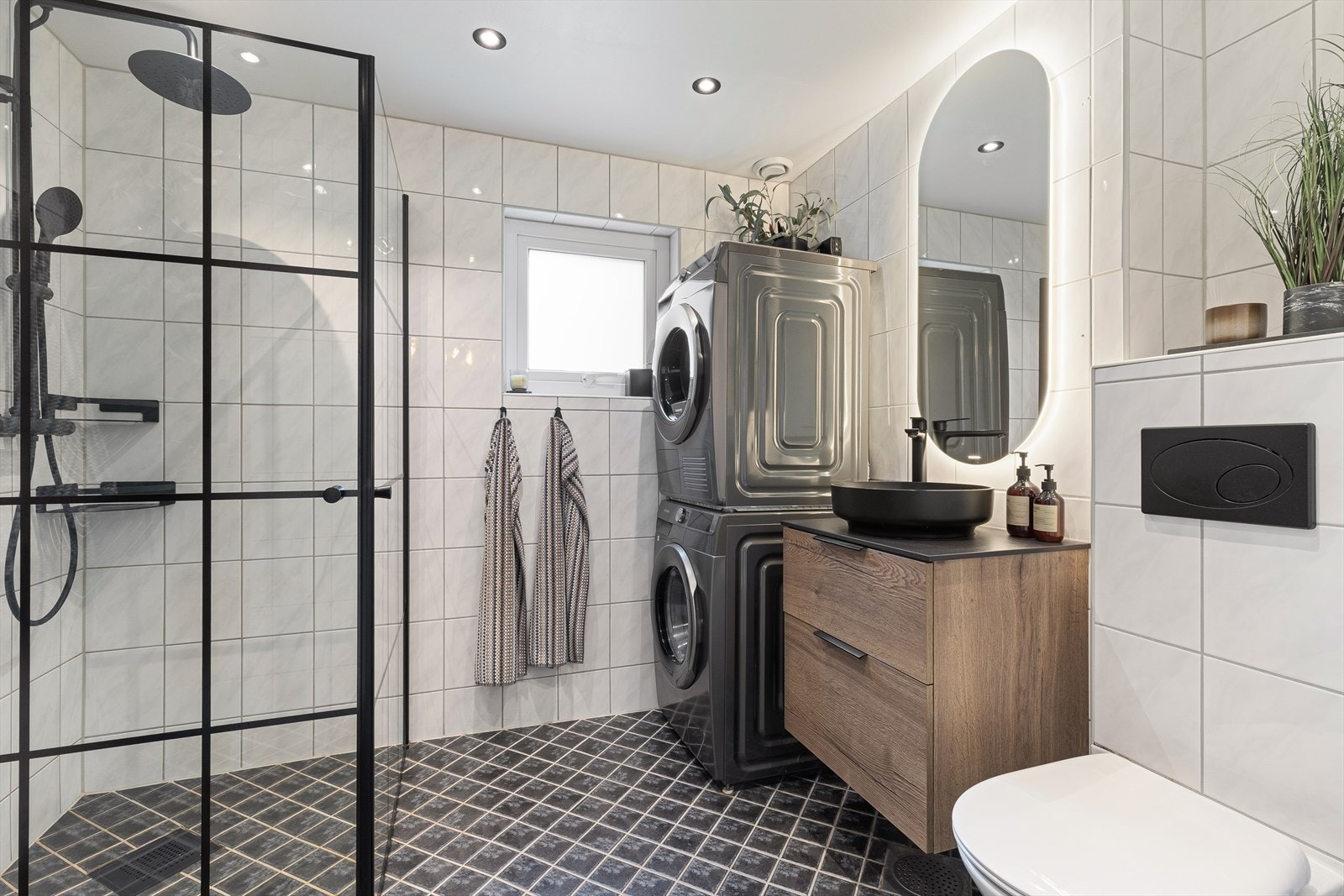 Flisagt bad med gulvvarme og downlights i himling. Badet ble pusset opp i regi av borettslaget i 2009, og eier byttet baderomsmøblement i 2021. Galleribilde