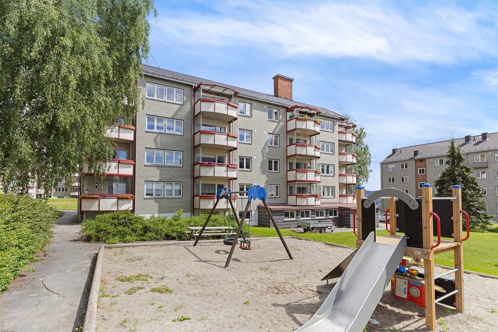 Fellesareal med sittegrupper og lekeapparater. Fellestomten er skjermet og barnevennlig innenfor borettslagets grenser. Galleribilde