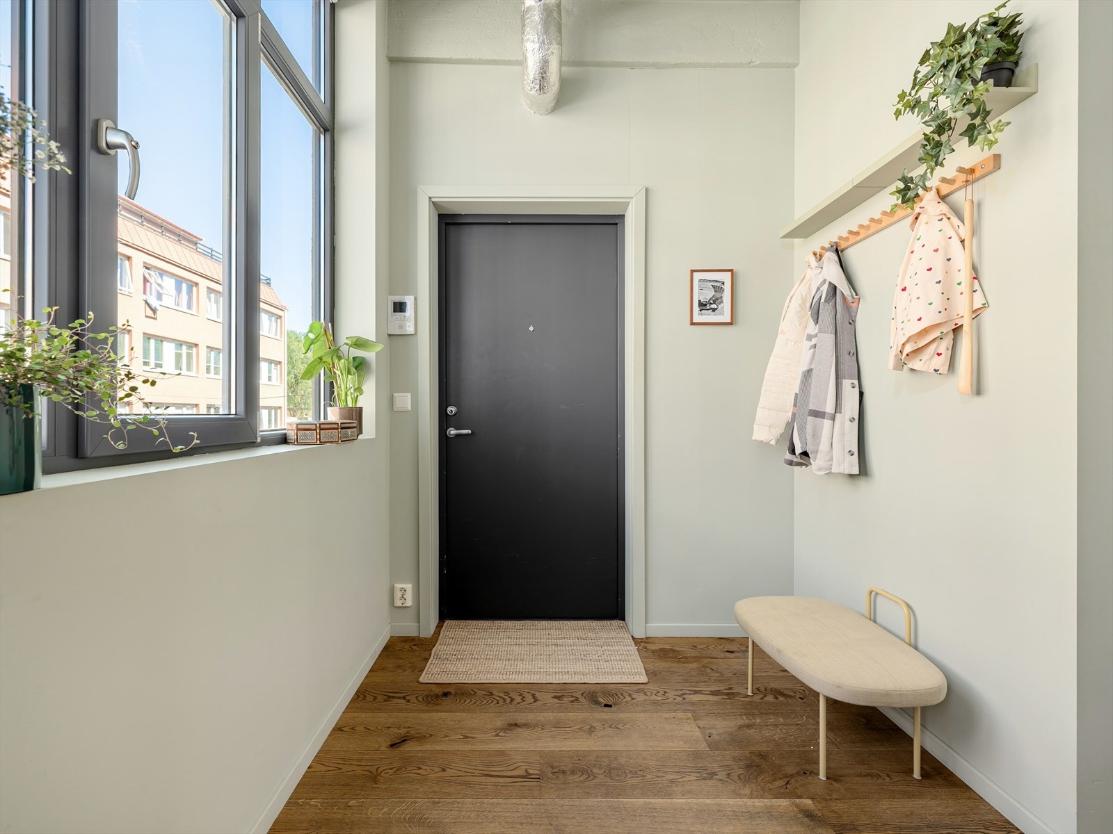 Det store og luftige inngangspartiet er malt i en dempet grønnfarge (Pale Linden fra Jotun). Her er det godt med plass til ulike oppbevaringsløsninger langs veggene. Galleribilde