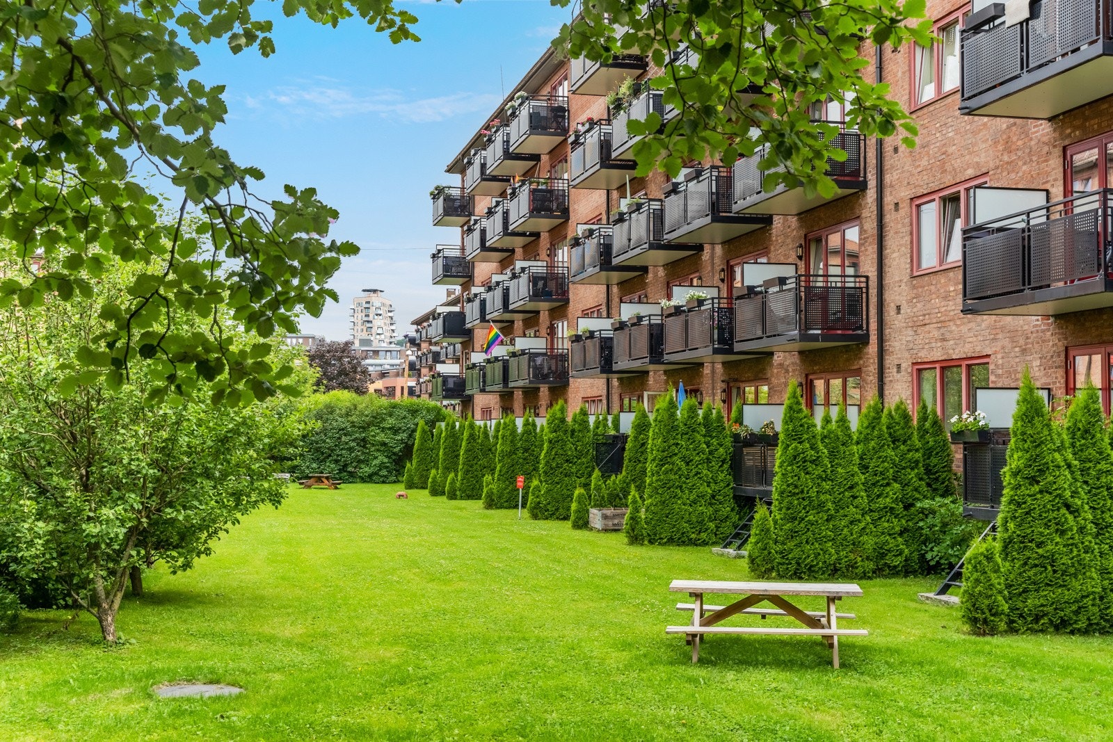 Idyllisk og pent opparbeidet fellesareal omkranset av grønne omgivelser. Galleribilde