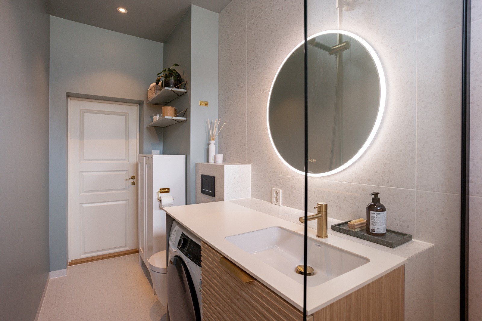 Badet har opplegg til vaskemaskin og skuffer, skap og hyller gir lagringsplass. Galleribilde