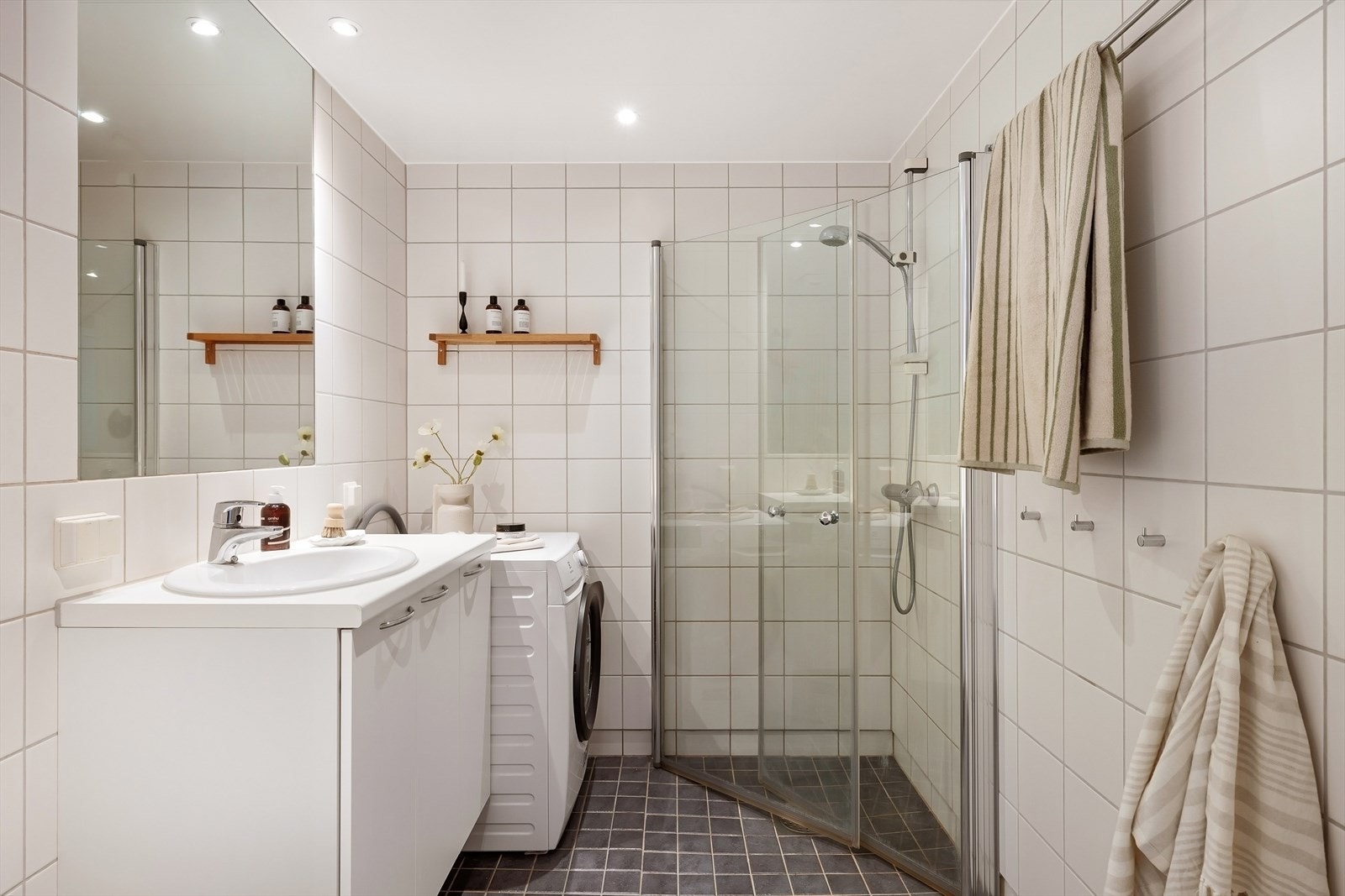 Leiligheten har et stort og romslig bad med dusj, servant med underskap, speil og toalett. Opplegg/plass til vaskemaskin. Galleribilde