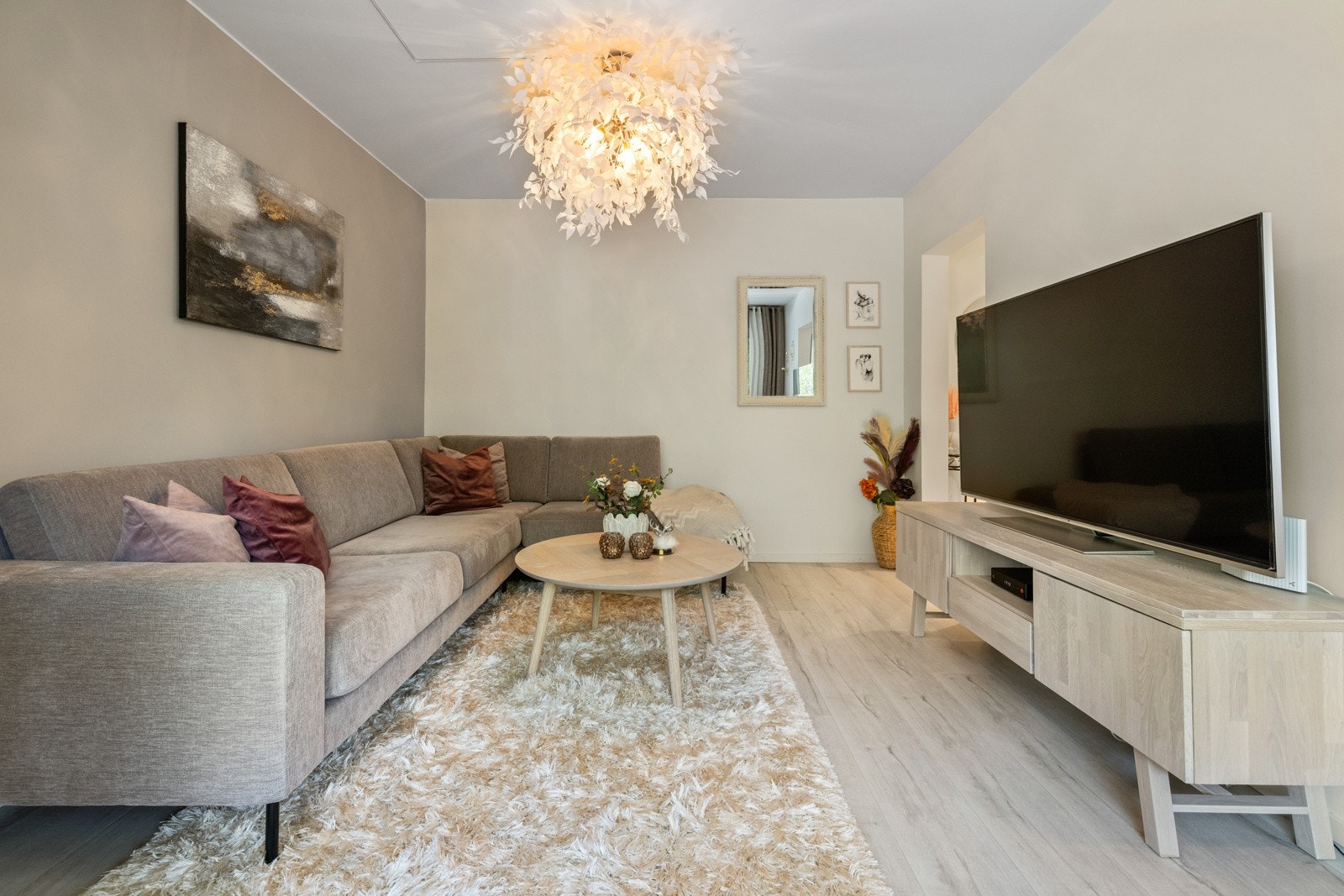Leiligheten har en meget pen stue med enstavs laminatgulv og vegger malt i en rolig fargepalett Galleribilde