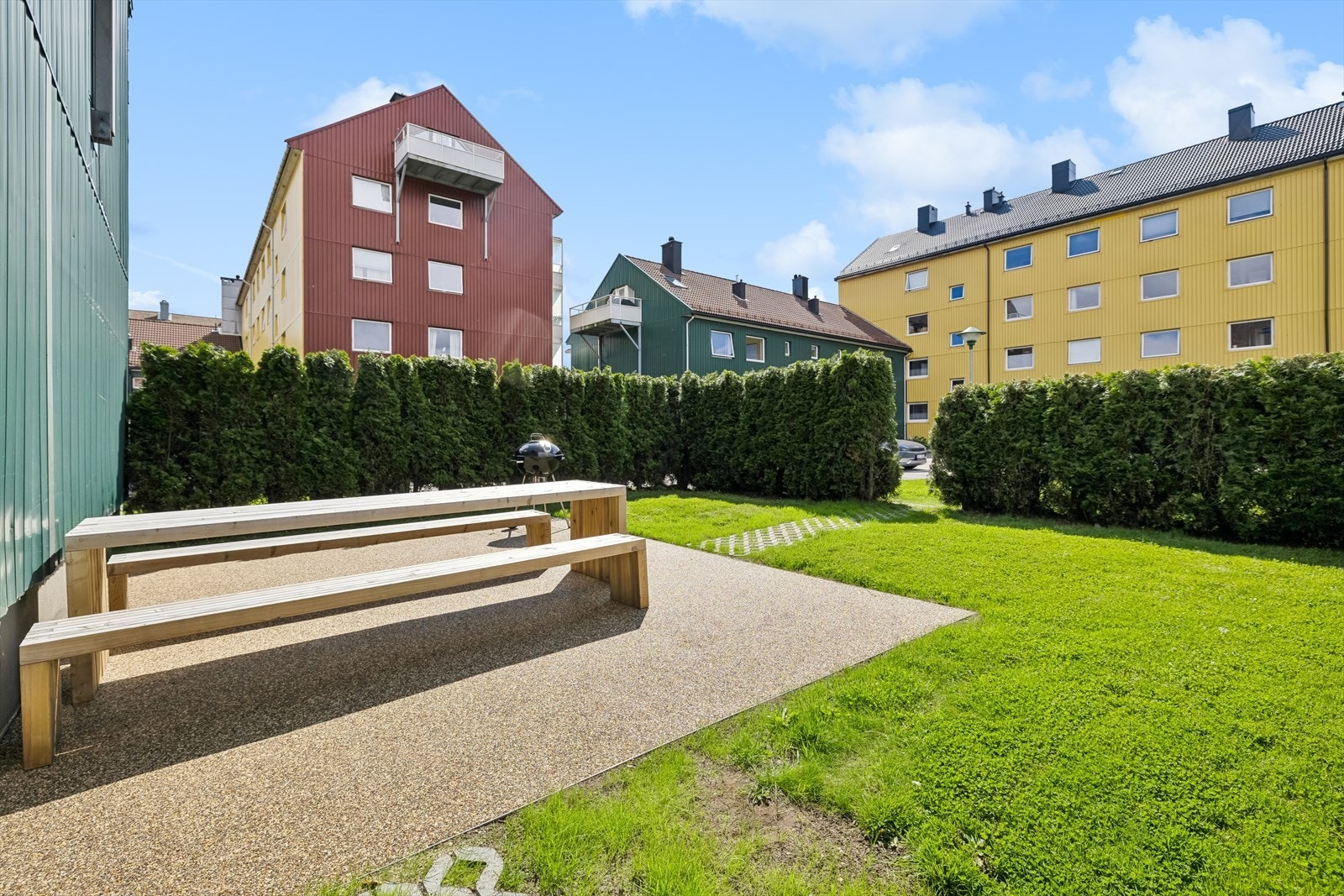Borettslaget har fine fellesområder med gressplen, grill og sitteplasser Galleribilde