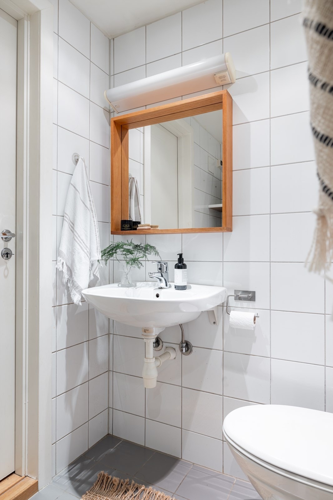 Pent og lyst flislagt bad med gulvvarme. Kombinasjonen av downlights og overlys over speil gir badet rikelig med lys. Galleribilde