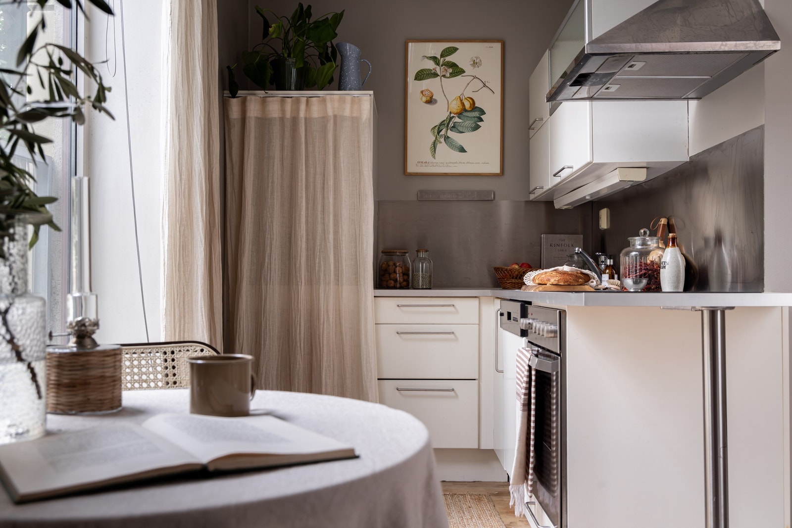 Det er integrert platetopp og stekeovn, samt frittstående kjøleskap bak forheng. Galleribilde