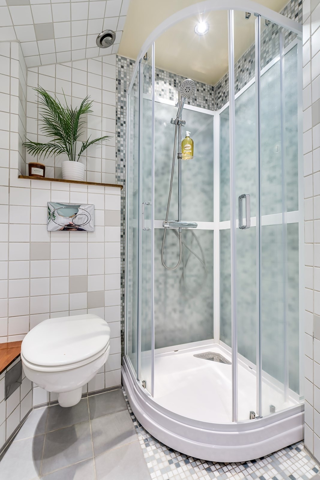Badet er innredet med dusjkabinett, vegghengt toalett og servant. Kabinettet var nytt i 2020. Galleribilde