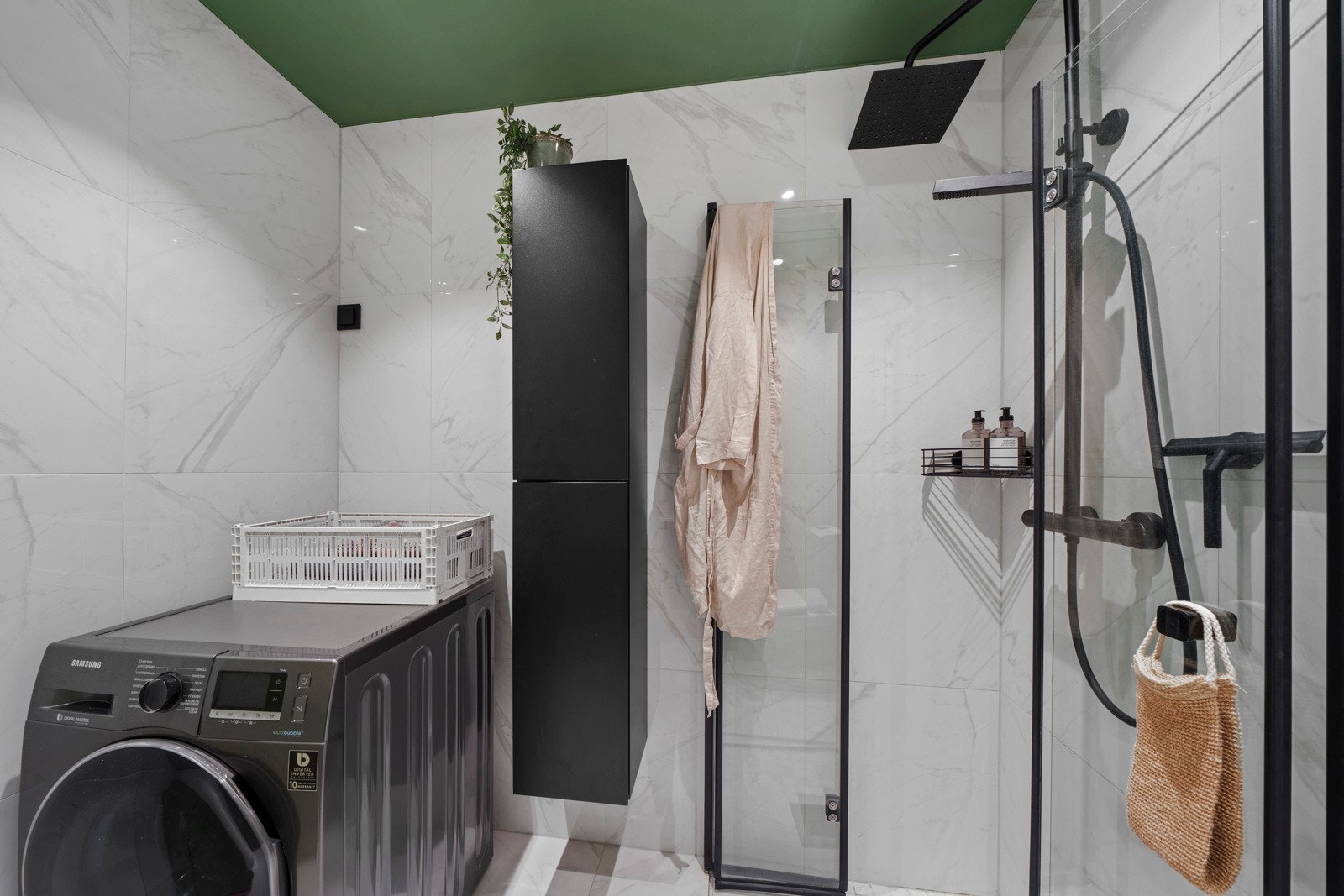 Badet er helflislagt med behagelig gulvvarme. Innredningen består av dusjhjørne med glassvegger, gulvmontert toalett og servant med speil. Galleribilde